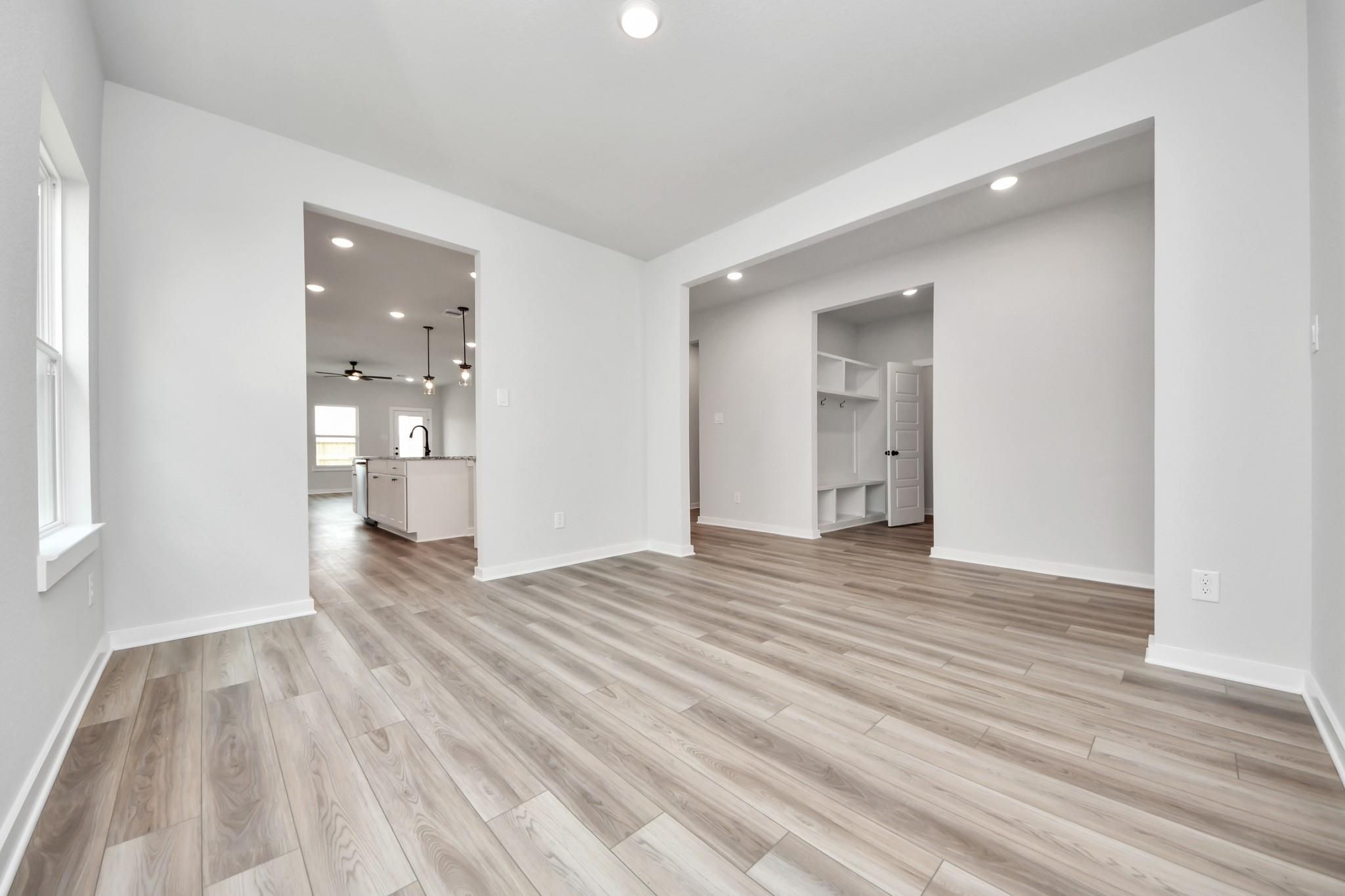 Open-concept living area with wood-look flooring, recessed lighting, and mudroom in The Sorrento E at Sundance Cove, Crosby.