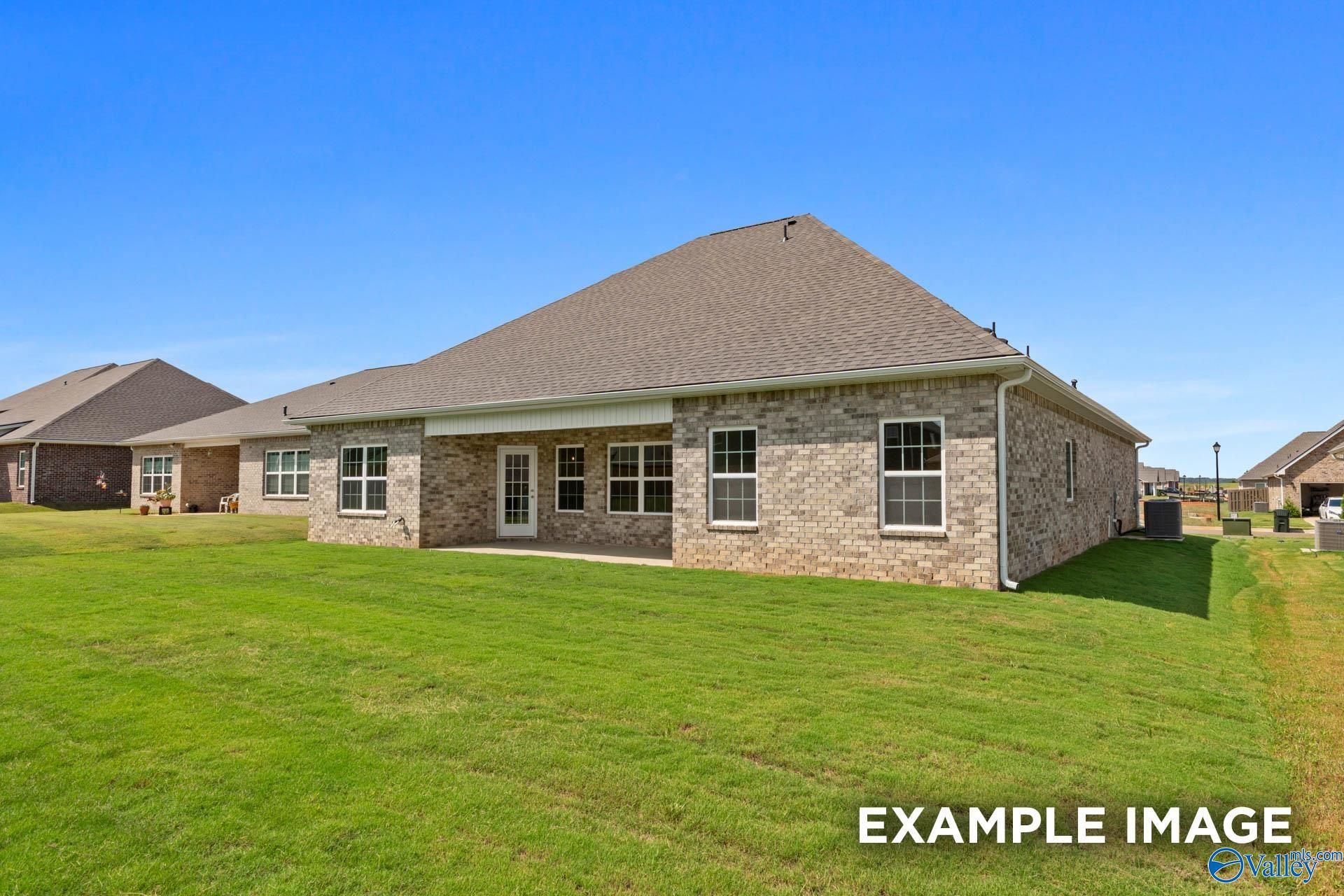 Brick exterior of The Rockford B floor plan with covered patio and spacious backyard in Kendall Downs, Toney, Alabama.