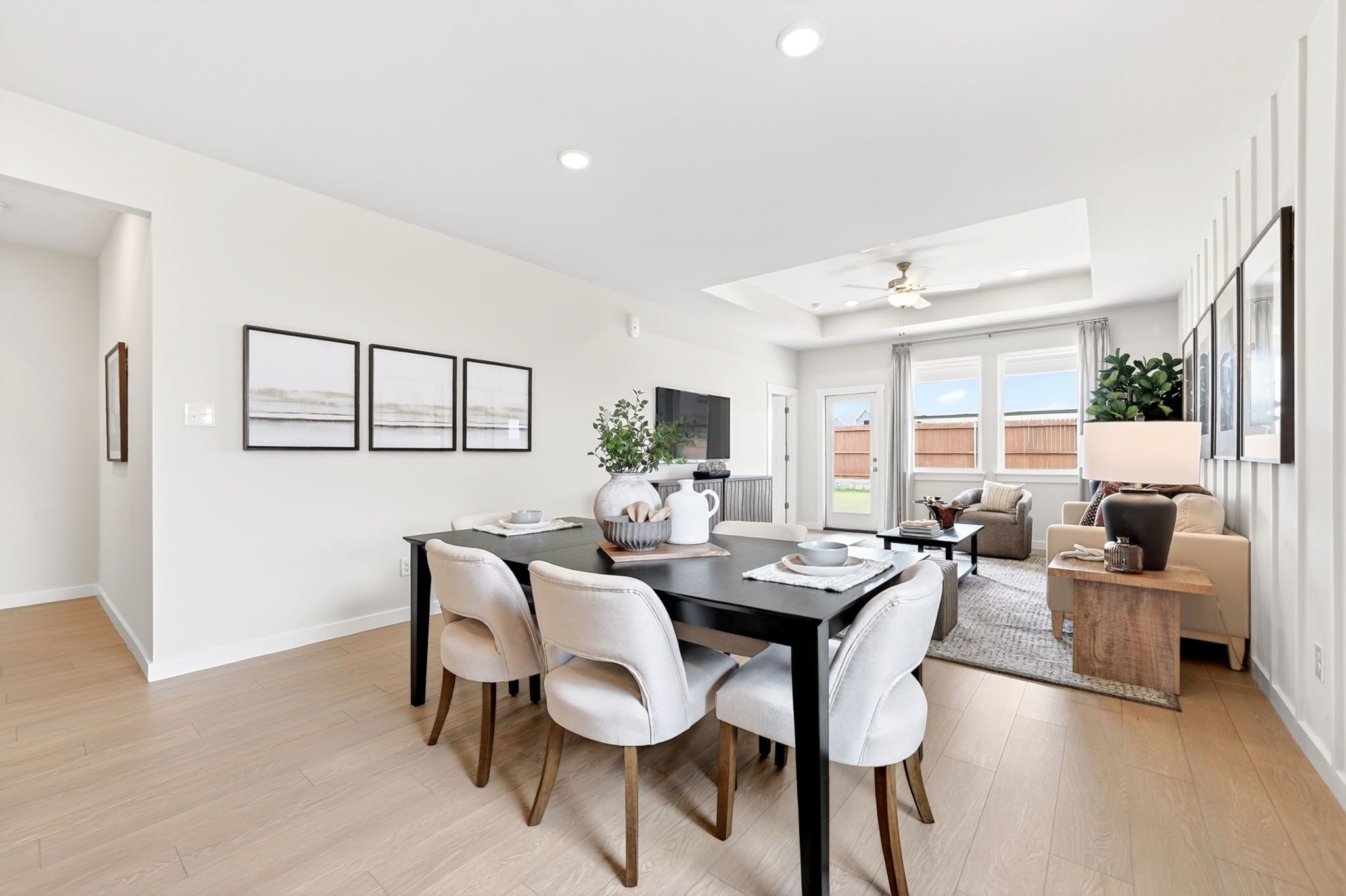 Open-concept dining and living area at Mesa Vista in San Antonio, TX by Davidson Homes with modern decor and wood floors.
