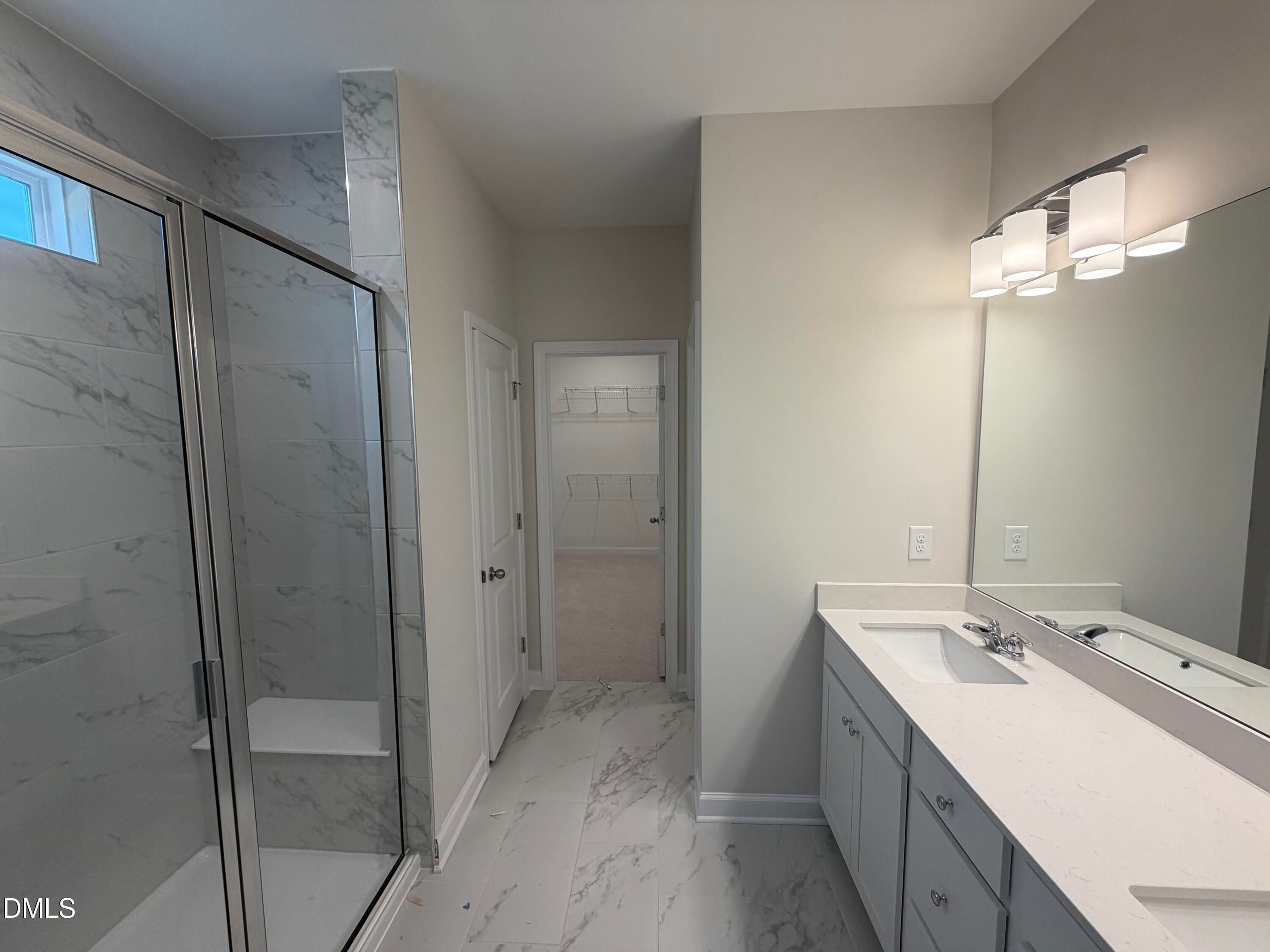 Elegant master bathroom with frameless glass shower, double vanity, quartz counters in Davidson Homes The Ash B, Lillington, NC