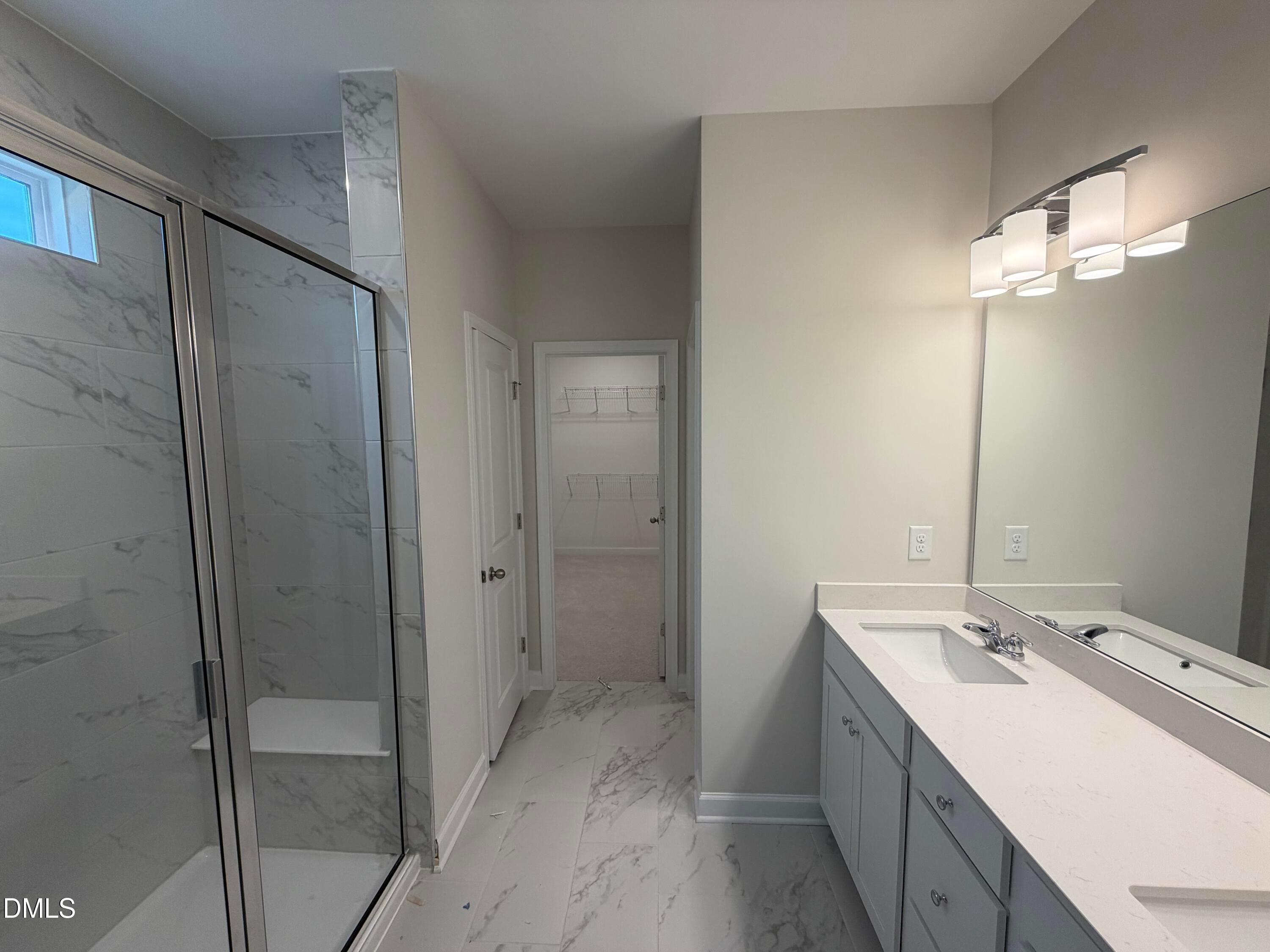 Elegant master bathroom with frameless glass shower, double vanity, quartz counters in Davidson Homes The Ash B, Lillington, NC