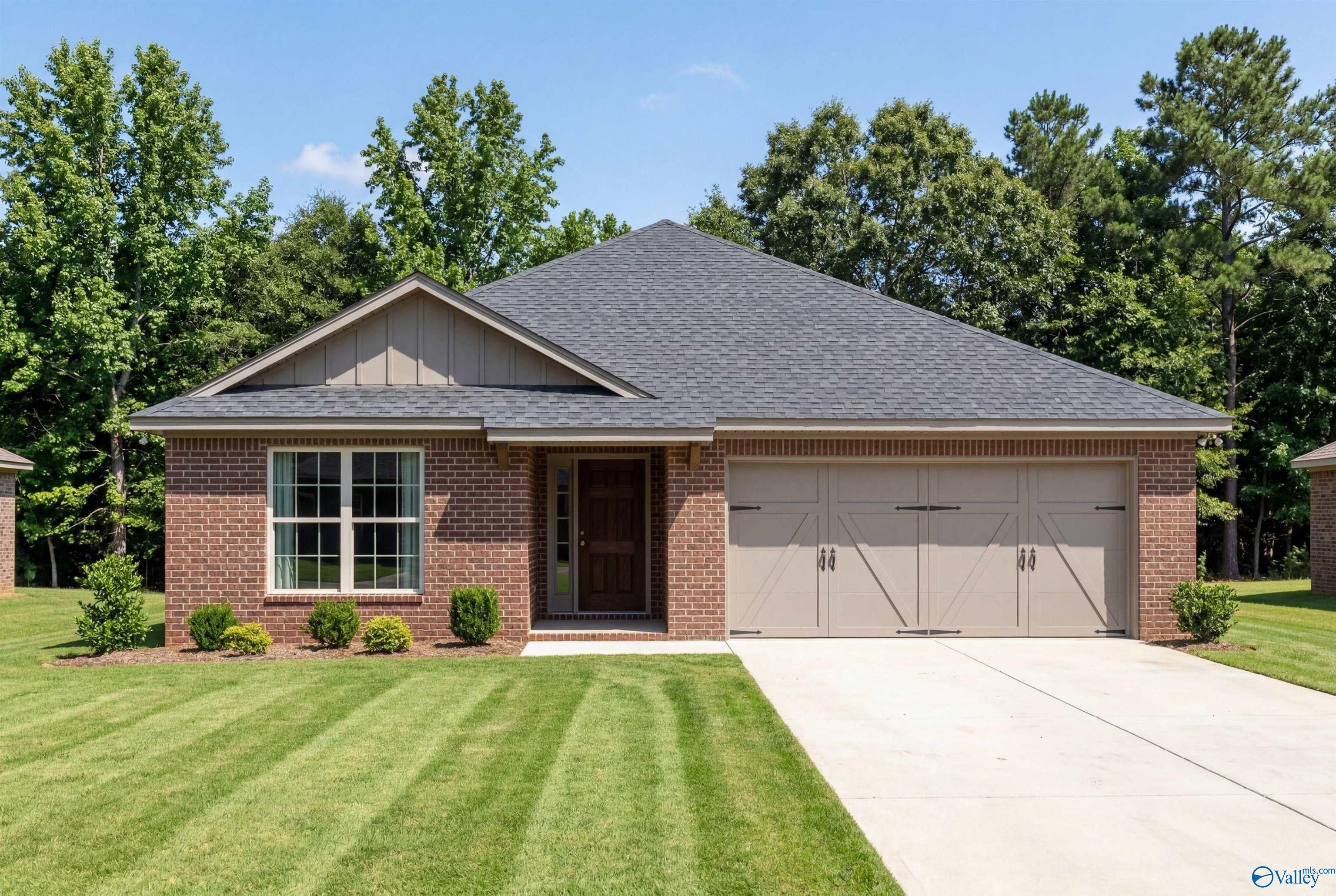 Single-story brick home with 2-car garage in The Franklin floor plan by Davidson Homes at Wood Trail, Toney, Alabama.