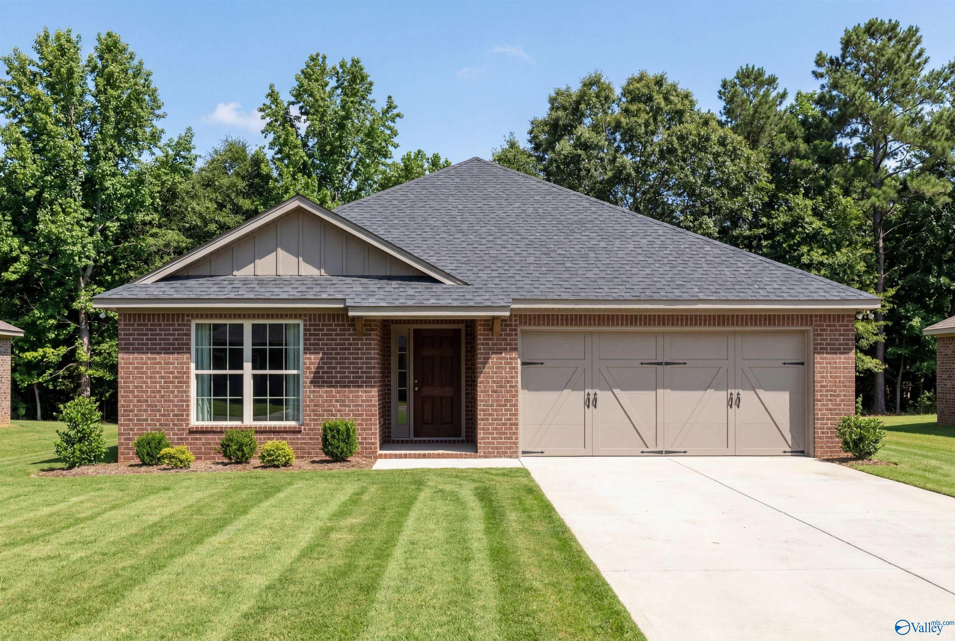 Single-story brick home with 2-car garage in The Franklin floor plan by Davidson Homes at Wood Trail, Toney, Alabama.