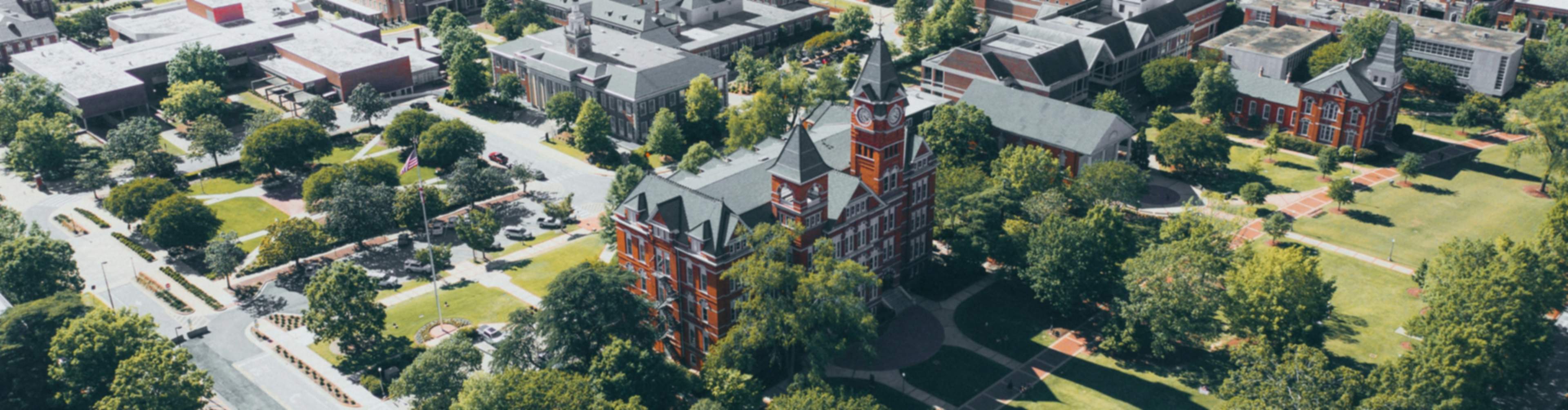 Aerial view of Auburn University campus with red brick buildings, green lawns, and surrounding neighborhoods in Auburn Region