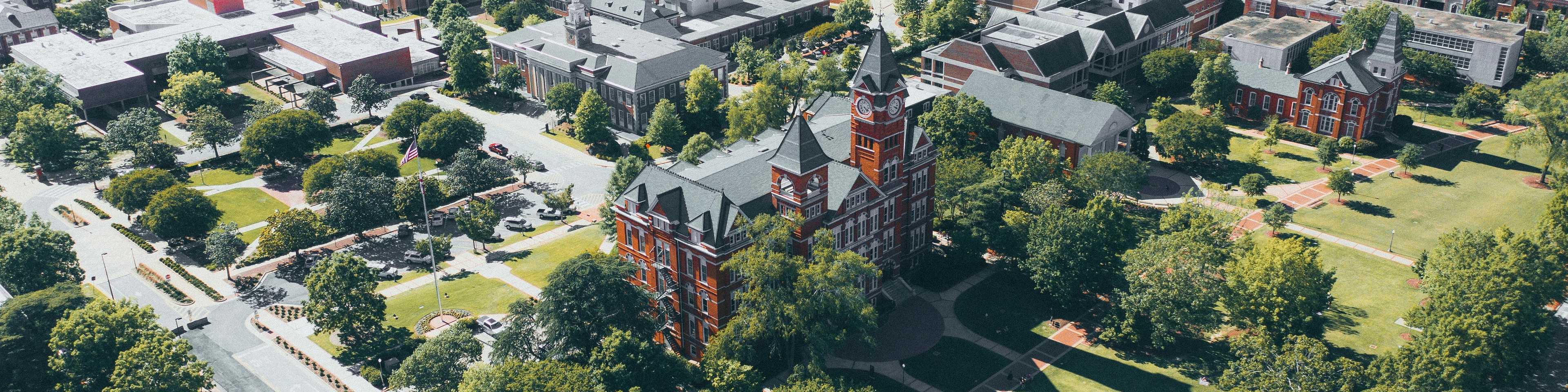 Aerial view of Auburn University campus with red brick buildings, green lawns, and surrounding neighborhoods in Auburn Region