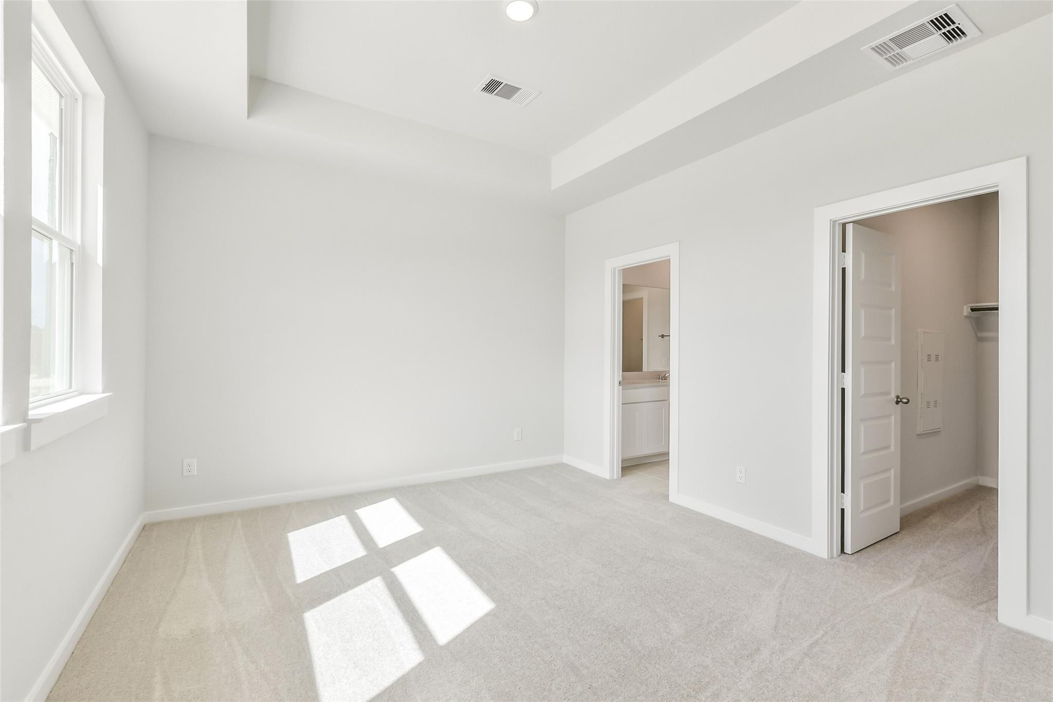 Bright master bedroom with en-suite bath and closet in Davidson Homes The Frio G, Spring Branch Crossing, Conroe Texas