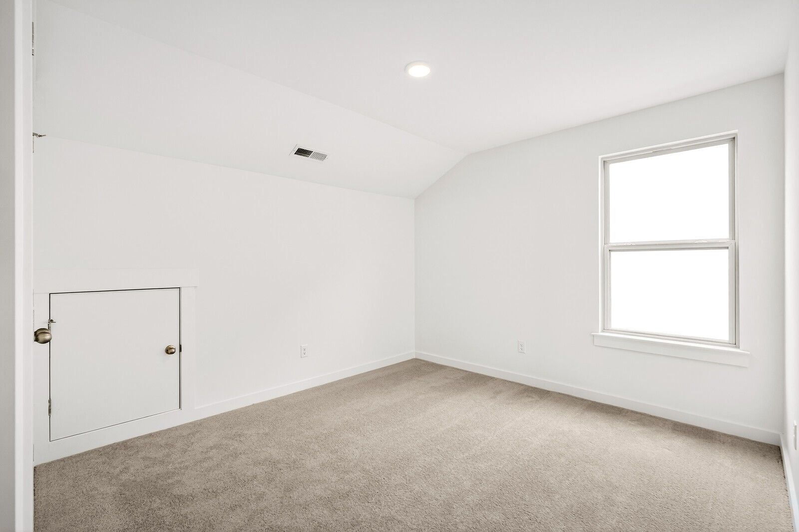 Bright upstairs bedroom with sloped ceiling, large window, and beige carpet in Davidson Homes The Ridgeport C, Gallatin, TN