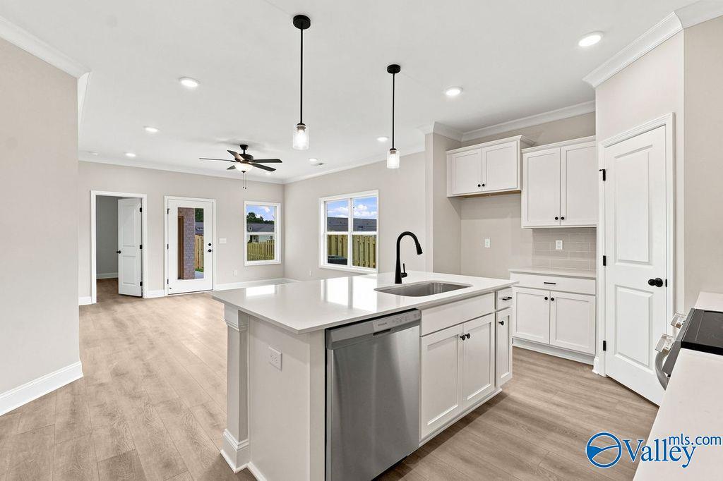 Open-concept kitchen with white cabinets and island in The Camilla B floor plan at The Retreat at Cain Park, Hartselle, AL.
