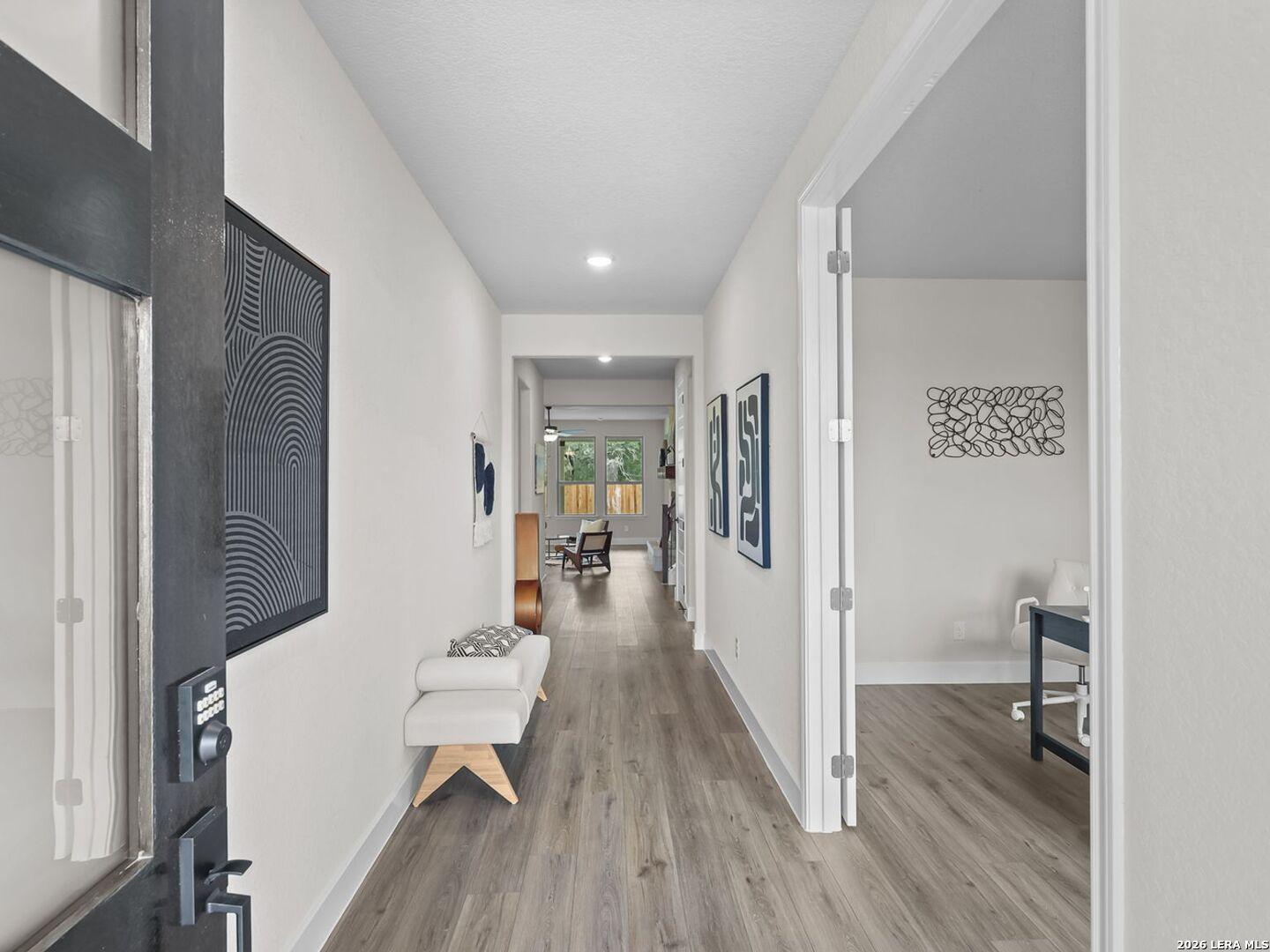 Bright entry hallway with wood-look flooring and adjacent home office in a Davidson Homes Belmont floor plan in Texas.
