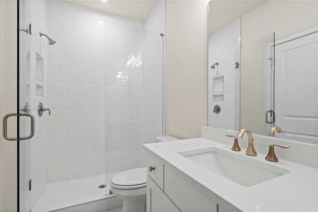 Modern white subway tile walk-in shower and quartz vanity bathroom in Davidson Homes The Arlington A, East Cobb, Georgia