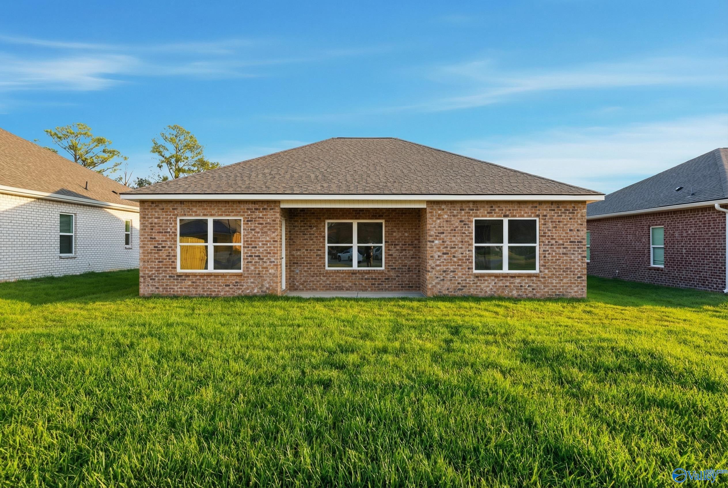 Front view of single-story brick home with 2-car garage, white-trimmed windows, and green lawn in Jaguar Hills, Huntsville, Alabama - The Asheville C by Davidson Homes