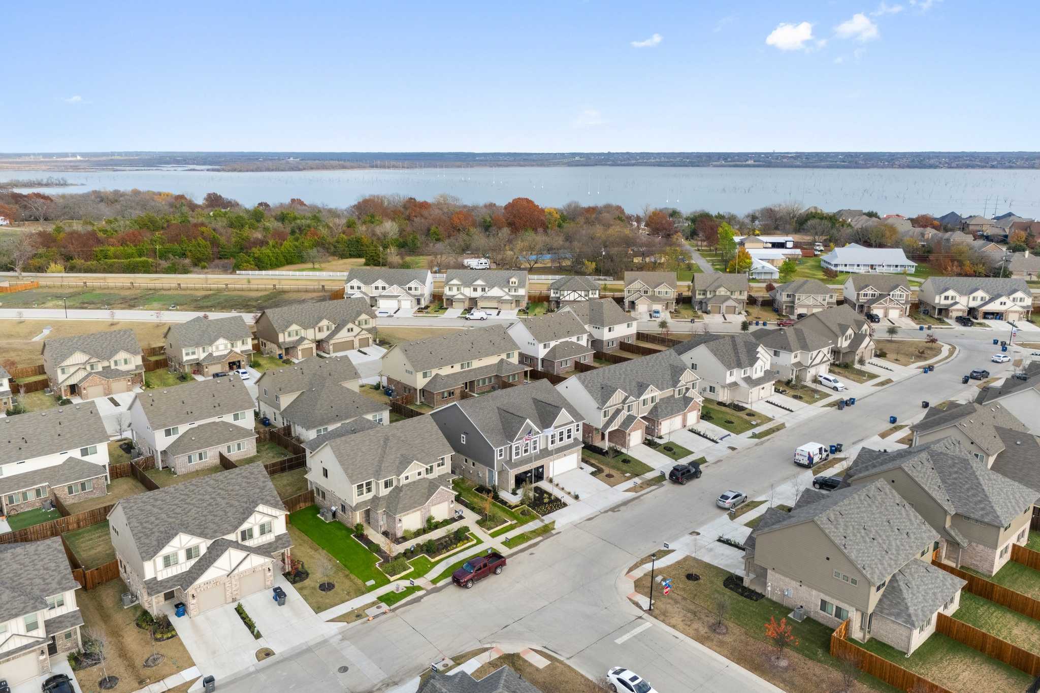 Aerial view of Lake Park Villas in Wylie Texas showcasing clustered modern homes streets and scenic lake horizon