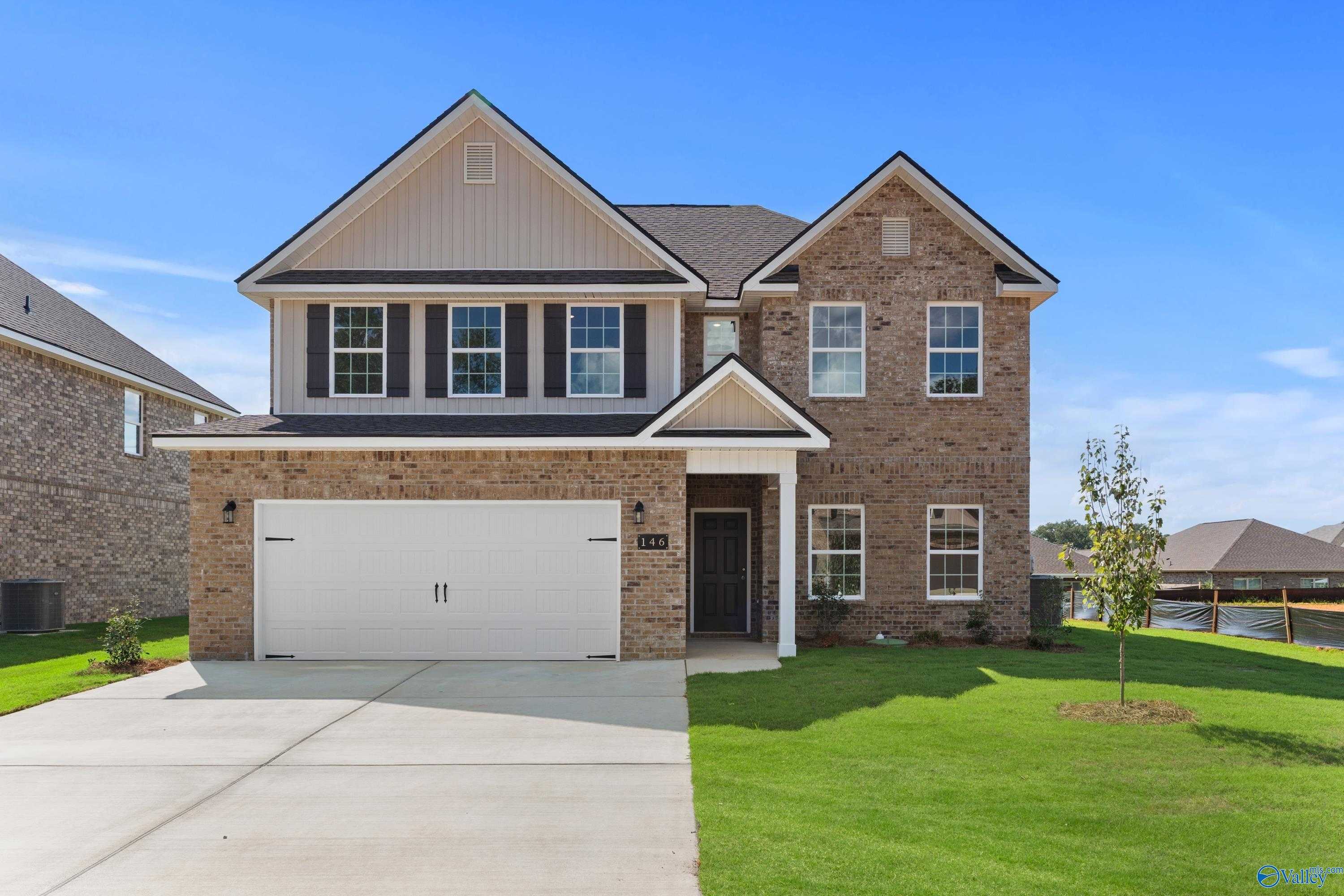 Two-story brick Davidson Homes Shelby A with 2-car garage, driveway, and lush lawn in Creek Grove, New Market, Alabama