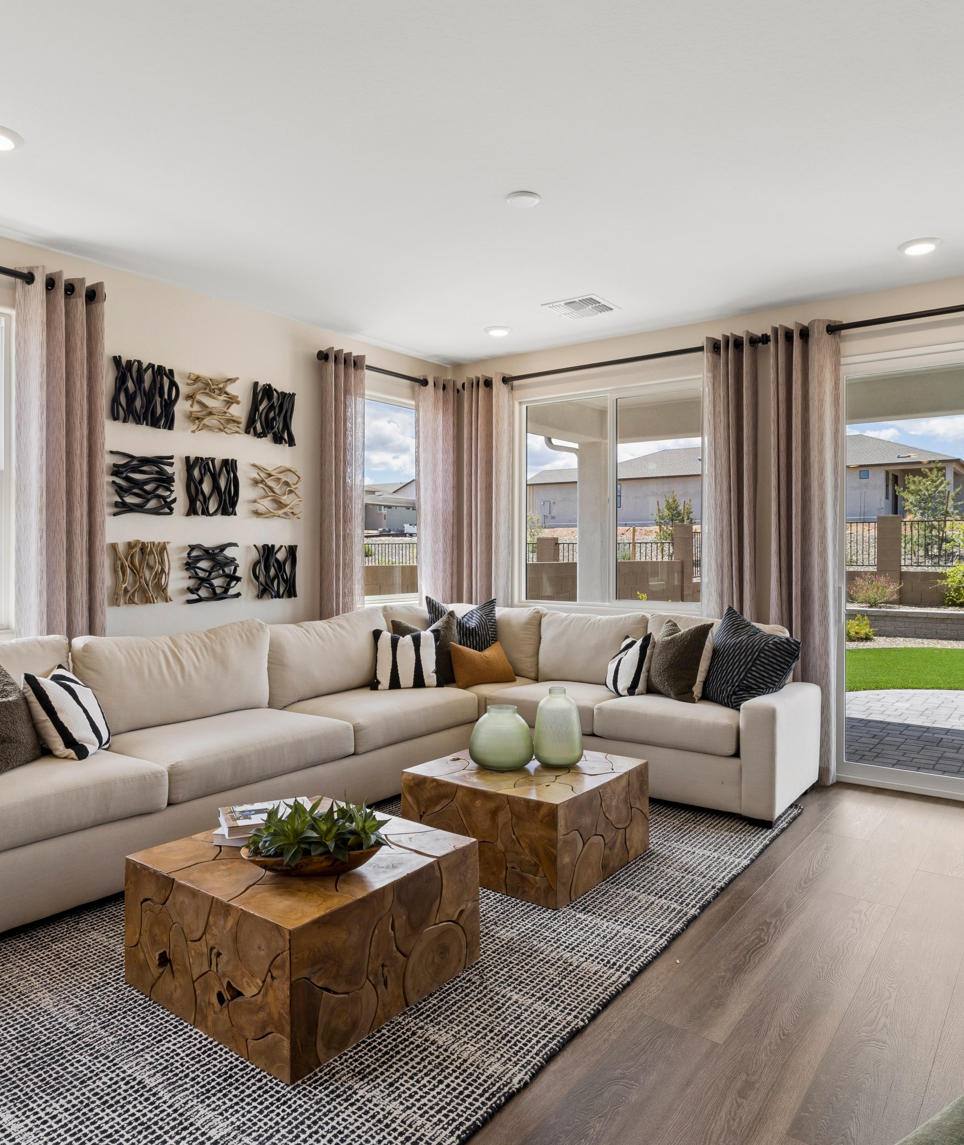 Spacious living room in South Ranch Western Collection, Prescott AZ with white sectional sofa, wood coffee table, fireplace, and large sliding doors