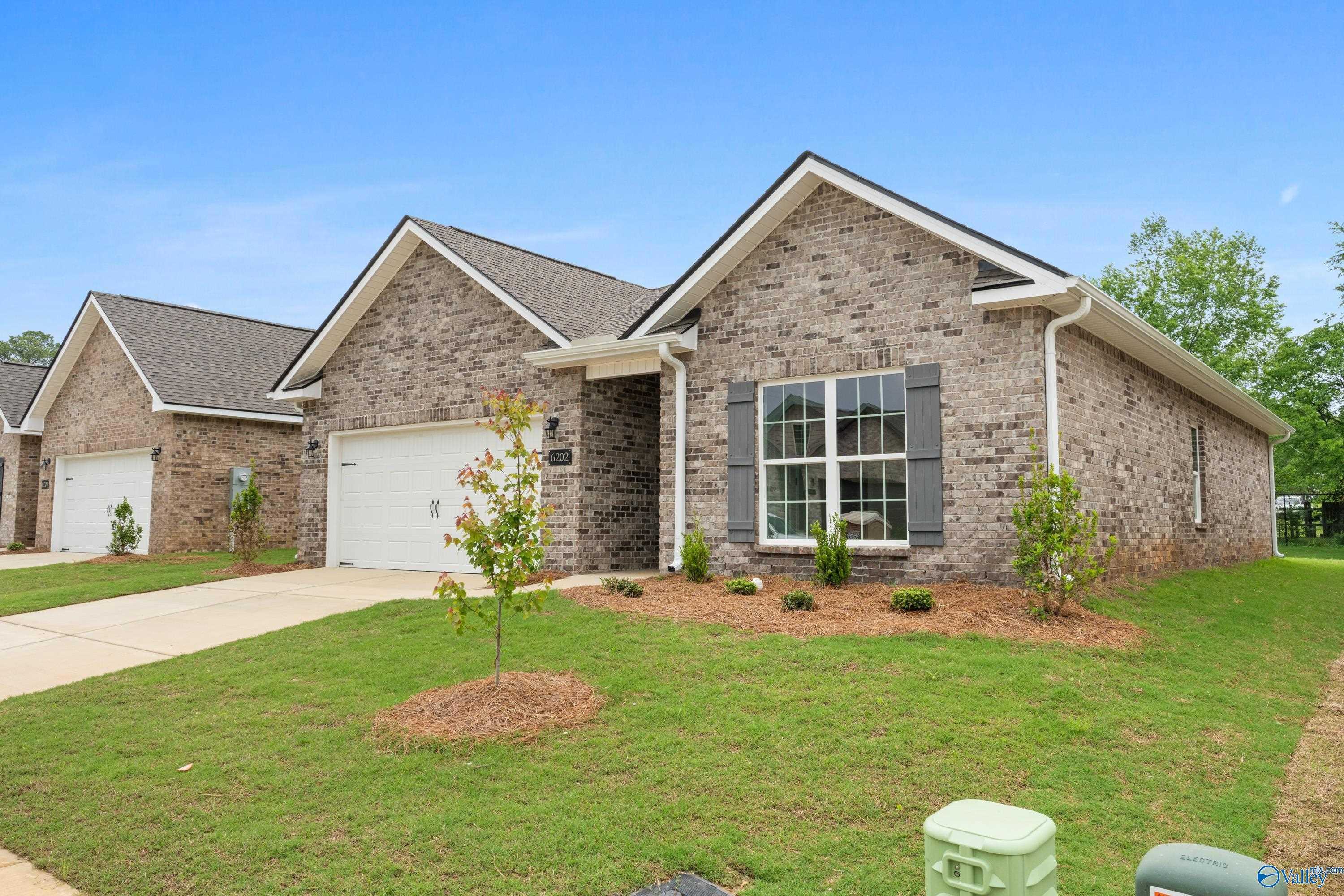Brick single-story home with 2-car garage, shutters, and landscaped yard in Jaguar Hills, Huntsville, Alabama