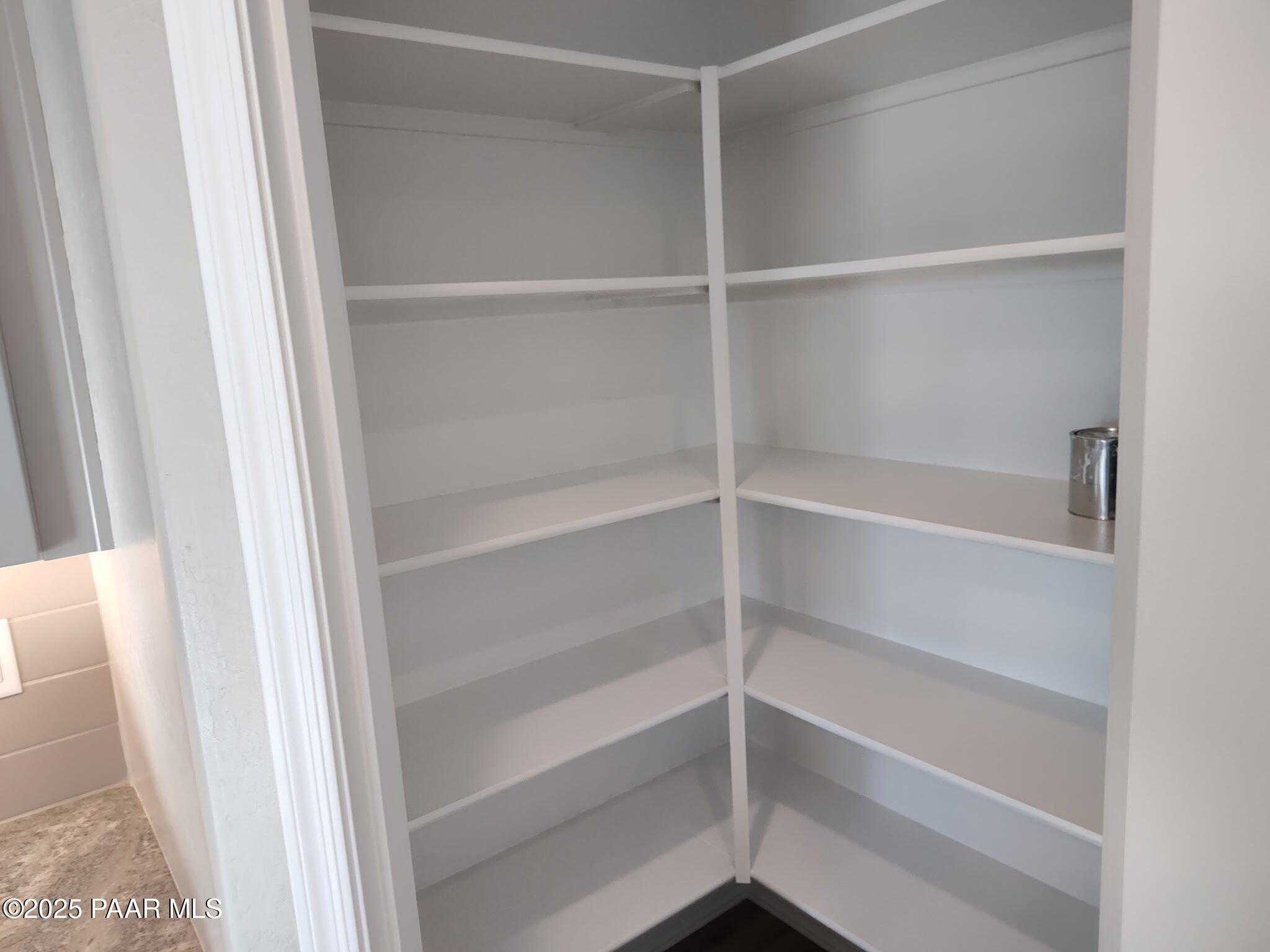 Spacious corner walk-in pantry with white wire shelves in Davidson Homes The Frontier C, Prescott Valley, Arizona