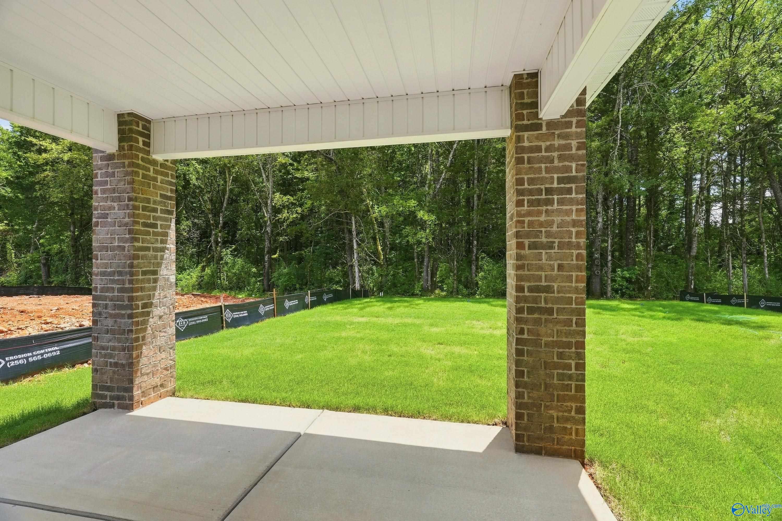 Covered brick patio overlooking a private backyard in Jaguar Hills, Huntsville, Alabama by Davidson Homes.
