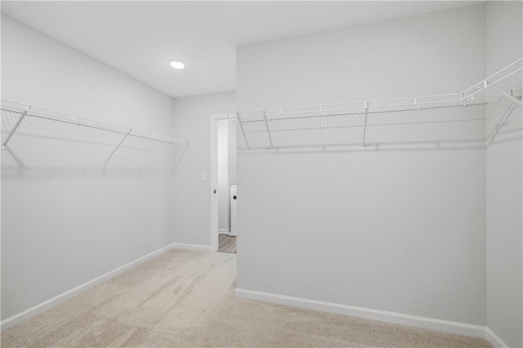 Spacious walk-in closet with white wire shelving and carpet in Davidson Homes Sinclair B plan, Greene Farm, Cartersville, Georgia