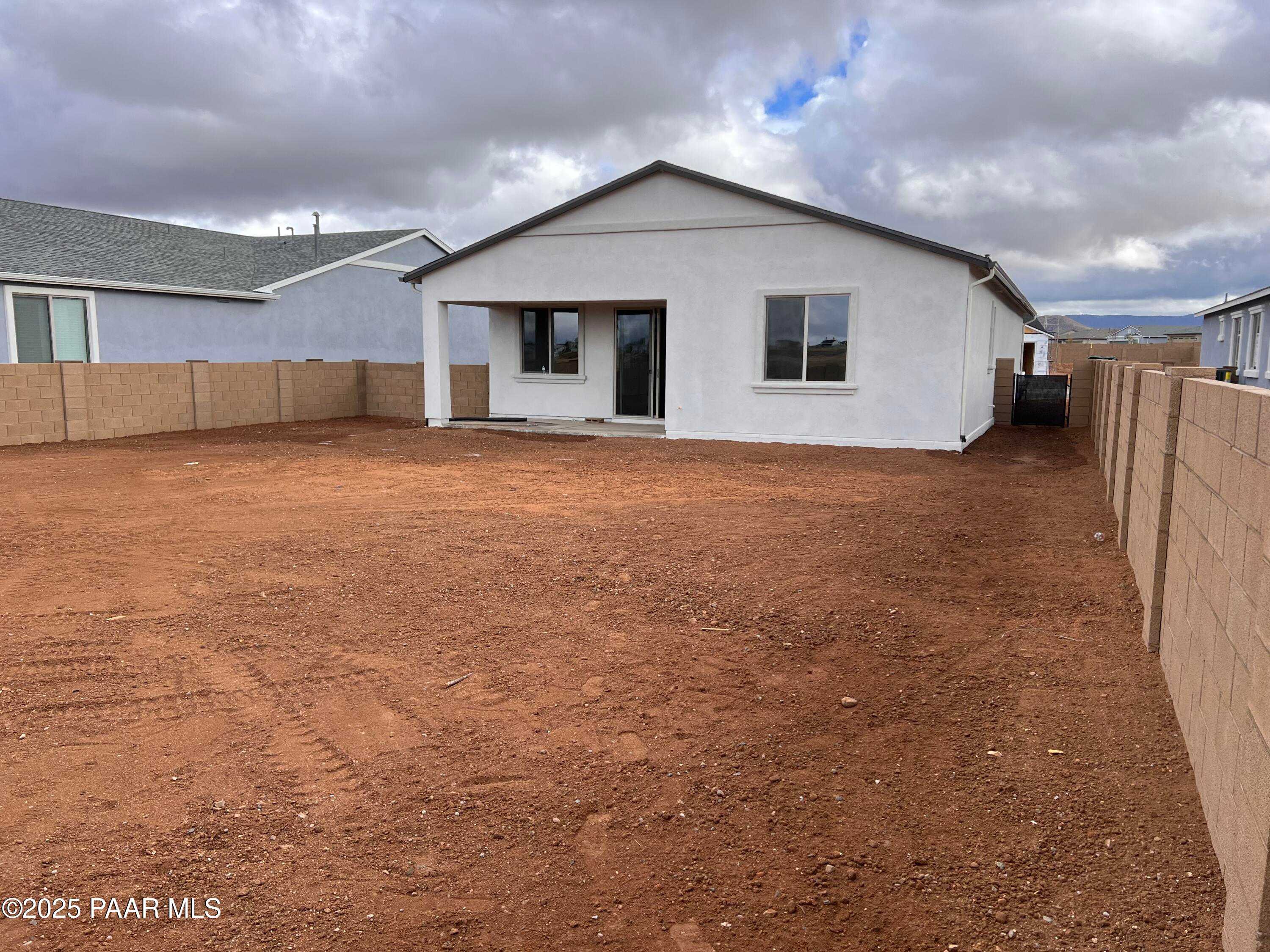 Front view of single-story The Frontier A home by Davidson Homes in North Ridge at Pronghorn Ranch, Prescott Valley, Arizona, with beige stucco and dirt yard