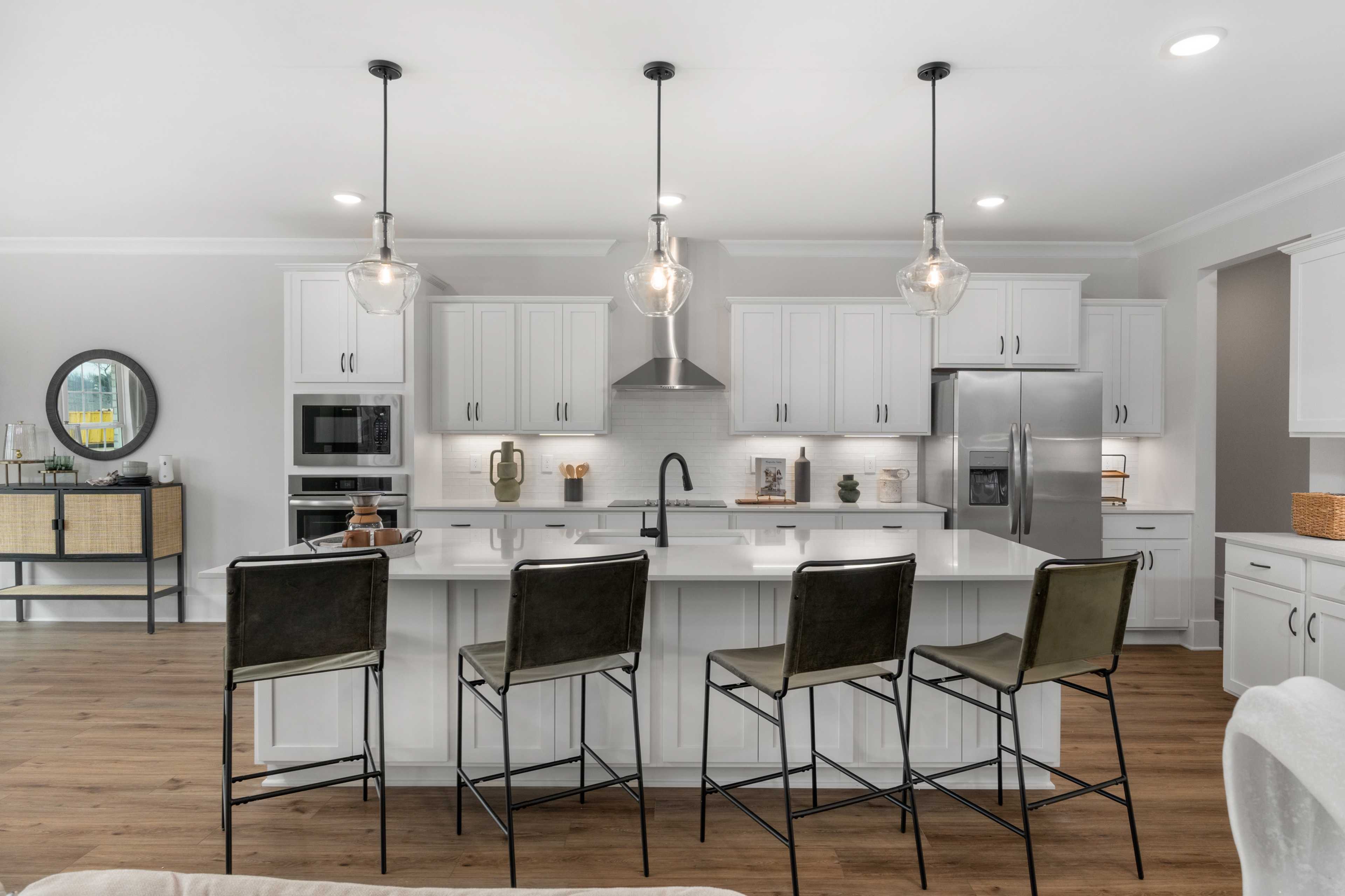 Spacious modern kitchen in Briercreek Meridianville AL with white cabinets, quartz island, pendant lights, stainless appliances