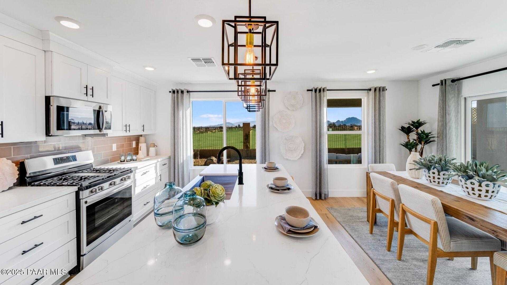 Modern open-concept kitchen with white quartz island, stainless appliances, and desert view in Davidson Homes Wilmington B, Prescott AZ