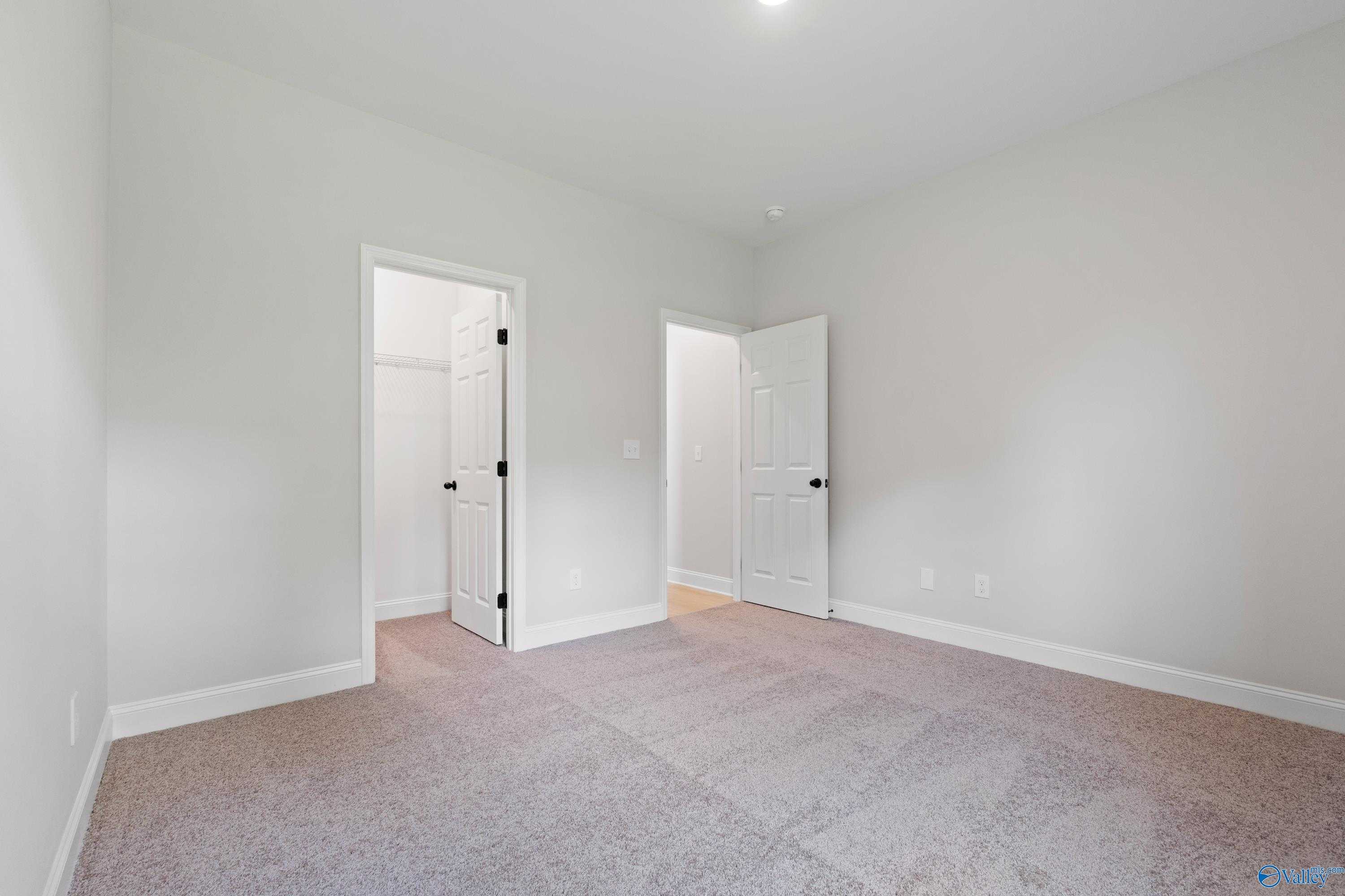 Spacious secondary bedroom featuring walk-in closet and en-suite door in Davidson Homes The Kirkland with Bonus, Harvest, Alabama