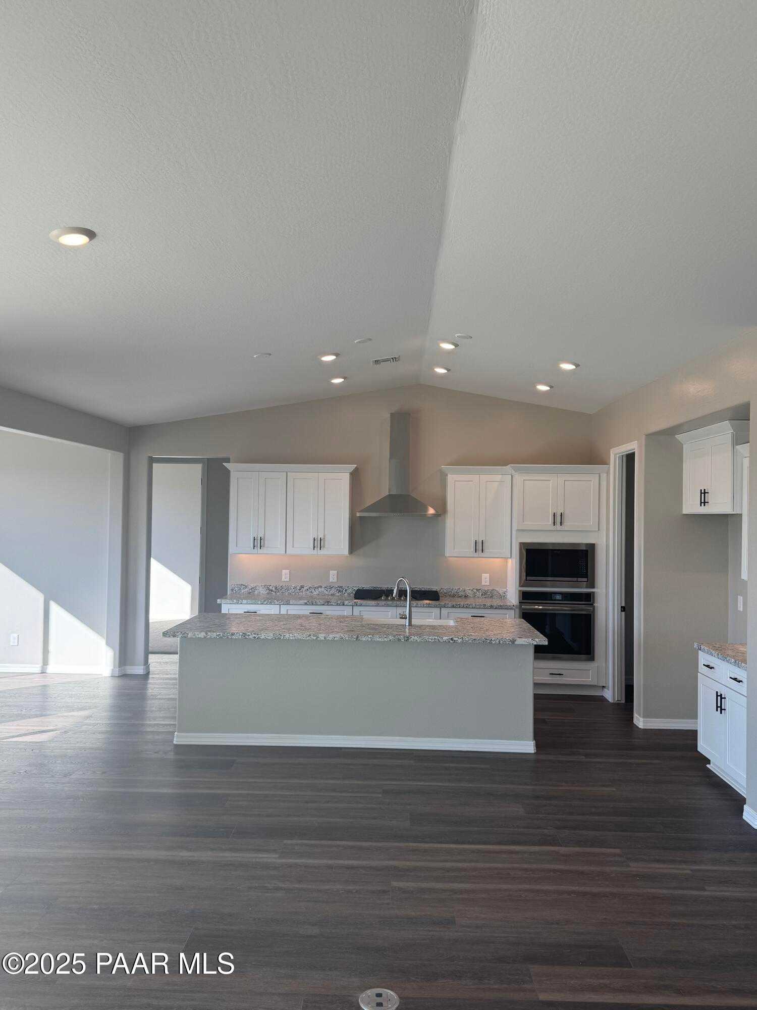 Modern open-concept kitchen with white shaker cabinets, quartz island, stainless appliances in Davidson Homes The Monarch E, Prescott AZ