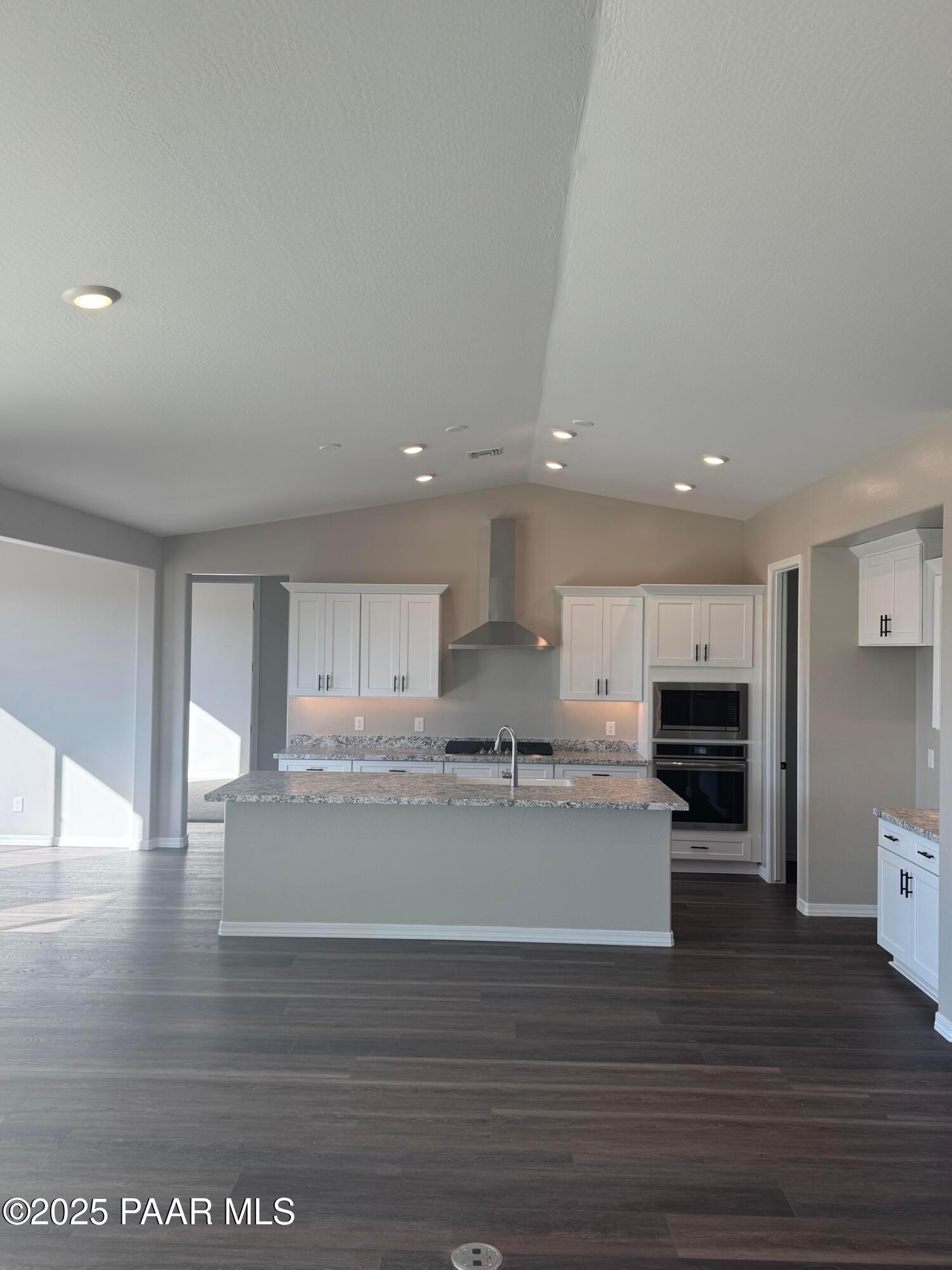 Modern open-concept kitchen with white shaker cabinets, quartz island, stainless appliances in Davidson Homes The Monarch E, Prescott AZ