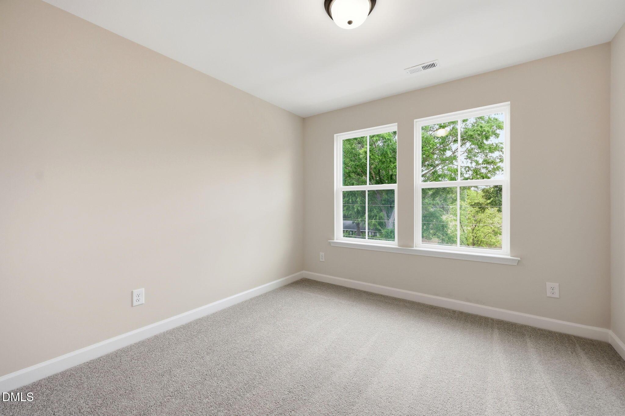 Bright, carpeted bedroom in The Mitchell floor plan at Camden Park, Knightdale, North Carolina.