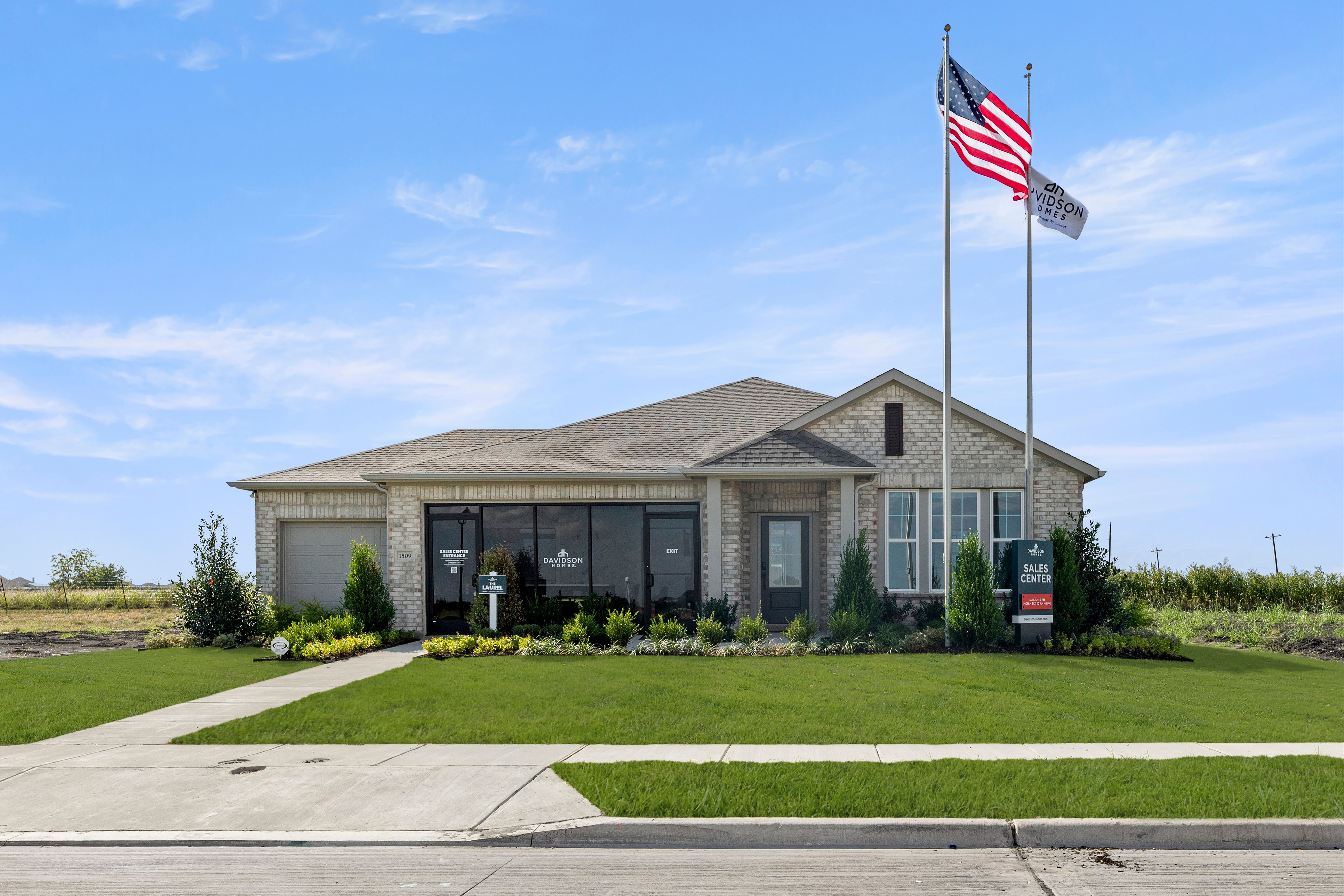 Modern brick model home exterior at Meadow Ridge Estates in Josephine Texas with large windows flags and landscaping