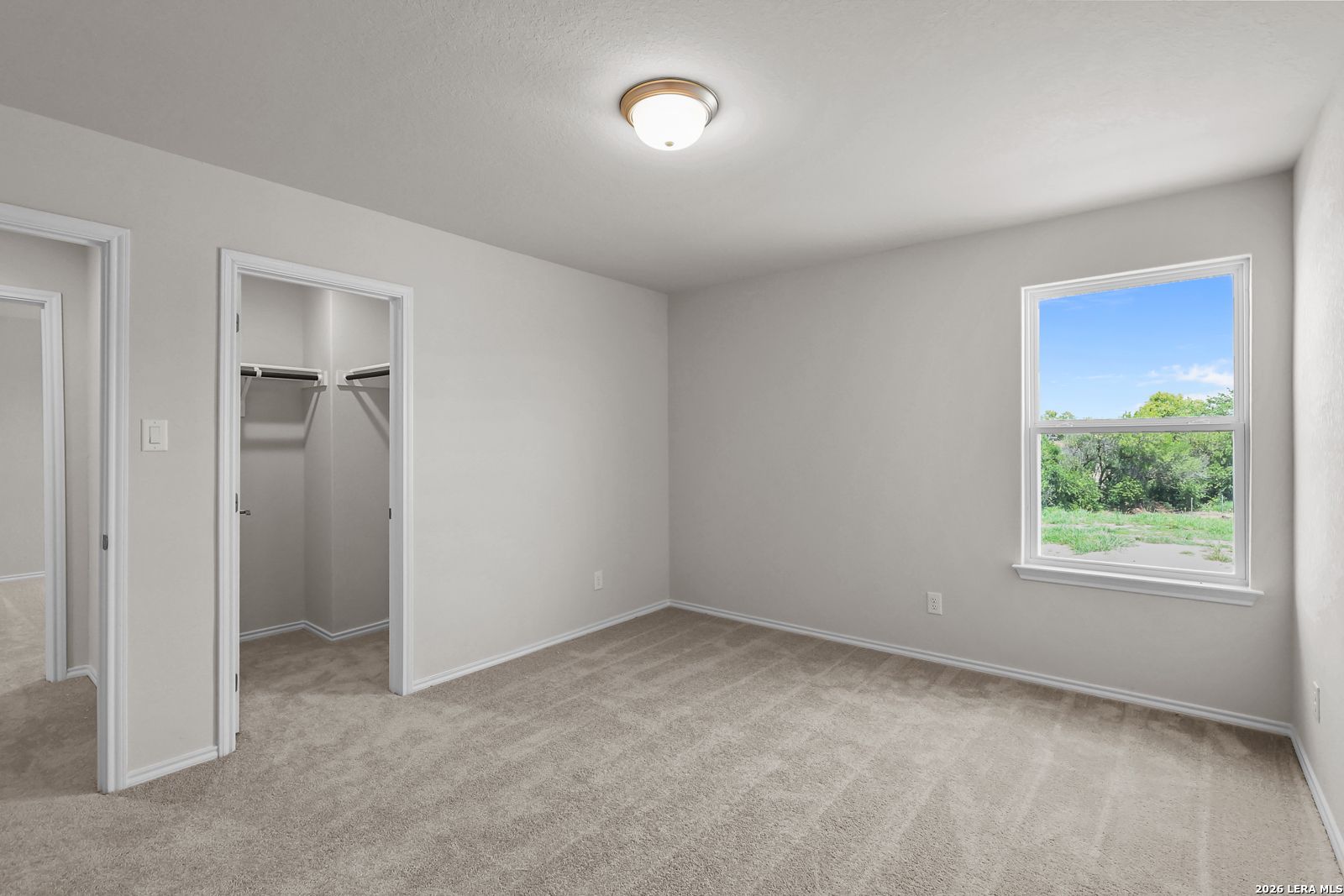 Bright secondary bedroom with walk-in closet in The San Marcos F floor plan at Rayburn Valley, San Antonio, Texas.