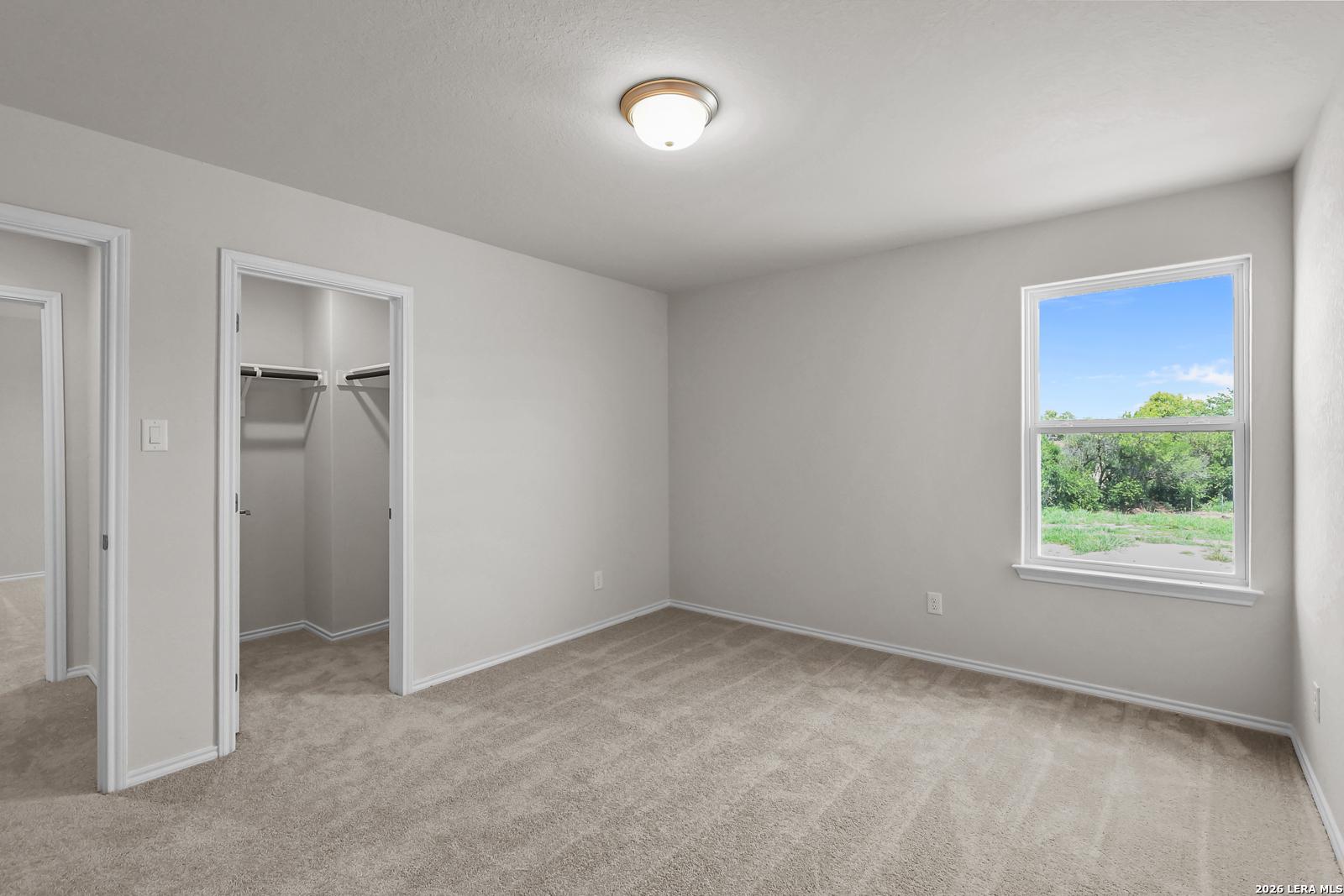 Bright secondary bedroom with walk-in closet in The San Marcos F floor plan at Rayburn Valley, San Antonio, Texas.