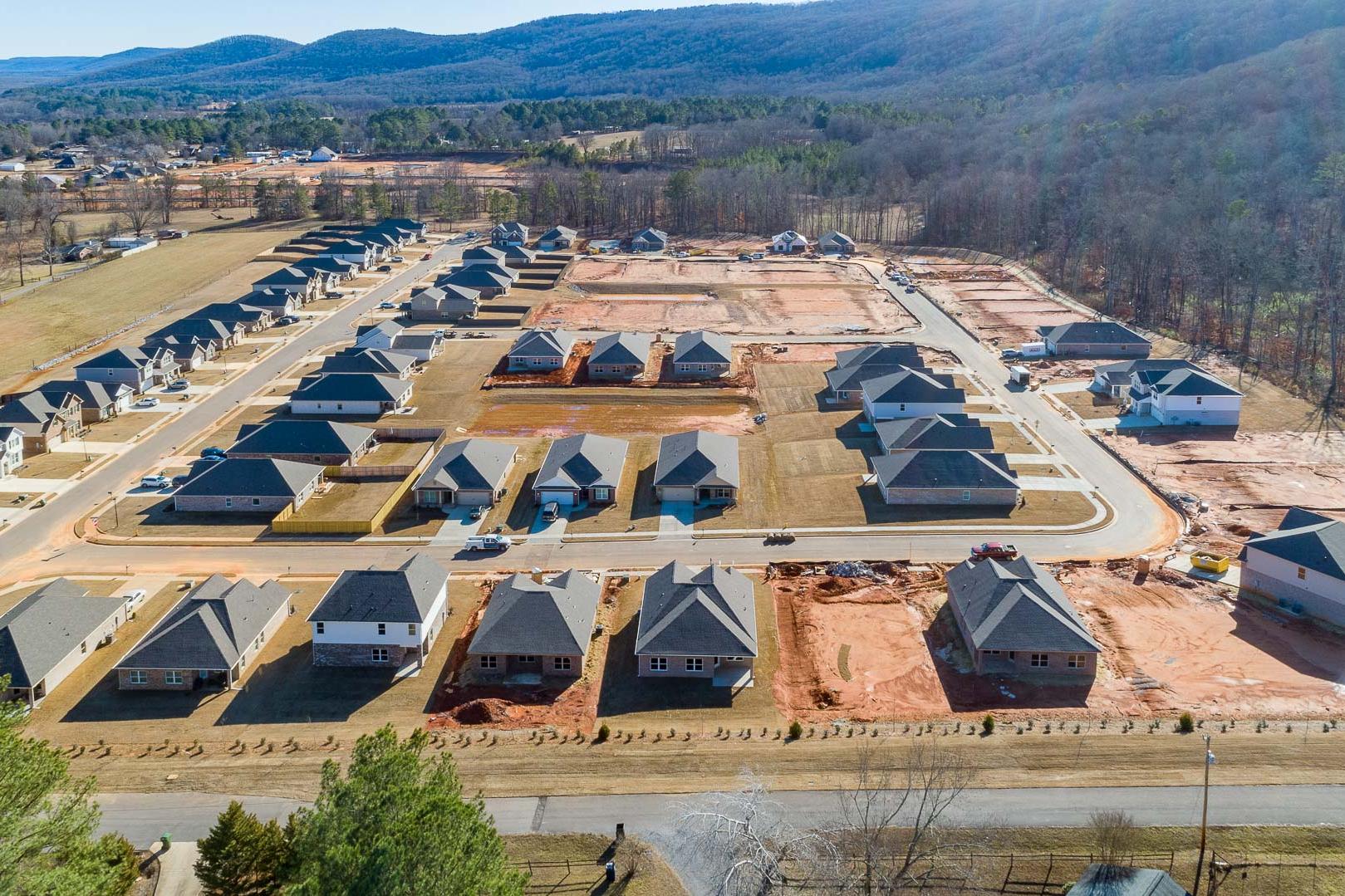Aerial view of new homes under construction at Monteagle Cove in Owens Cross Roads, Alabama amid wooded hills and mountains