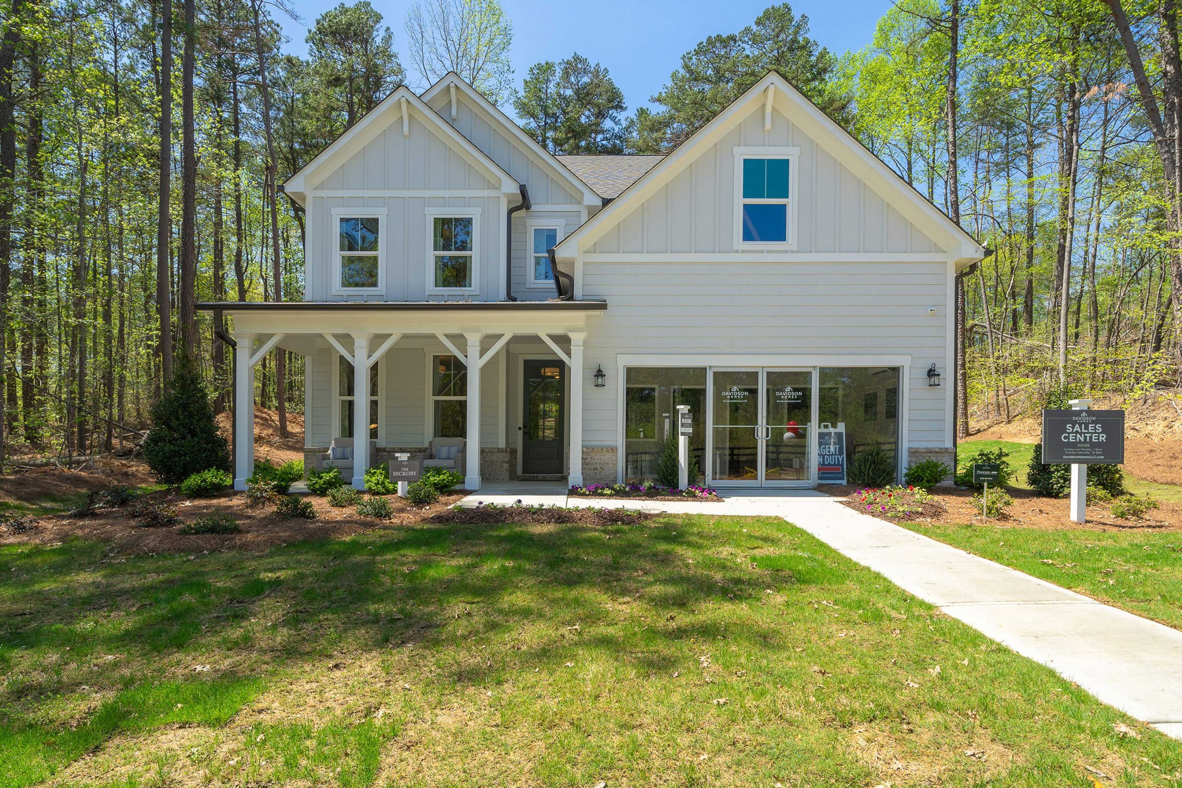 Modern farmhouse home exterior at Riverwood in Dallas, Georgia by Davidson Homes with covered porch and wooded lot