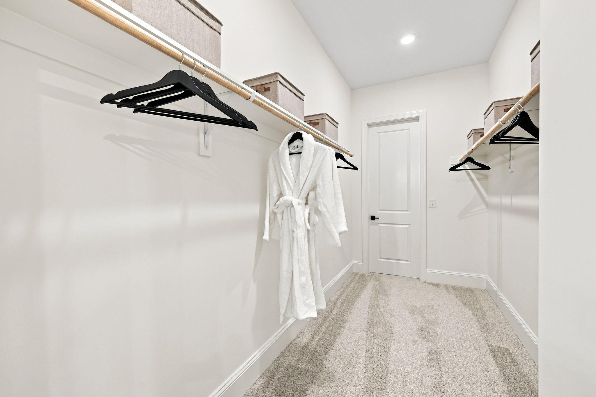 Spacious walk-in closet in The Barrington C master suite featuring white shelving, plush carpeting, and organized storage.