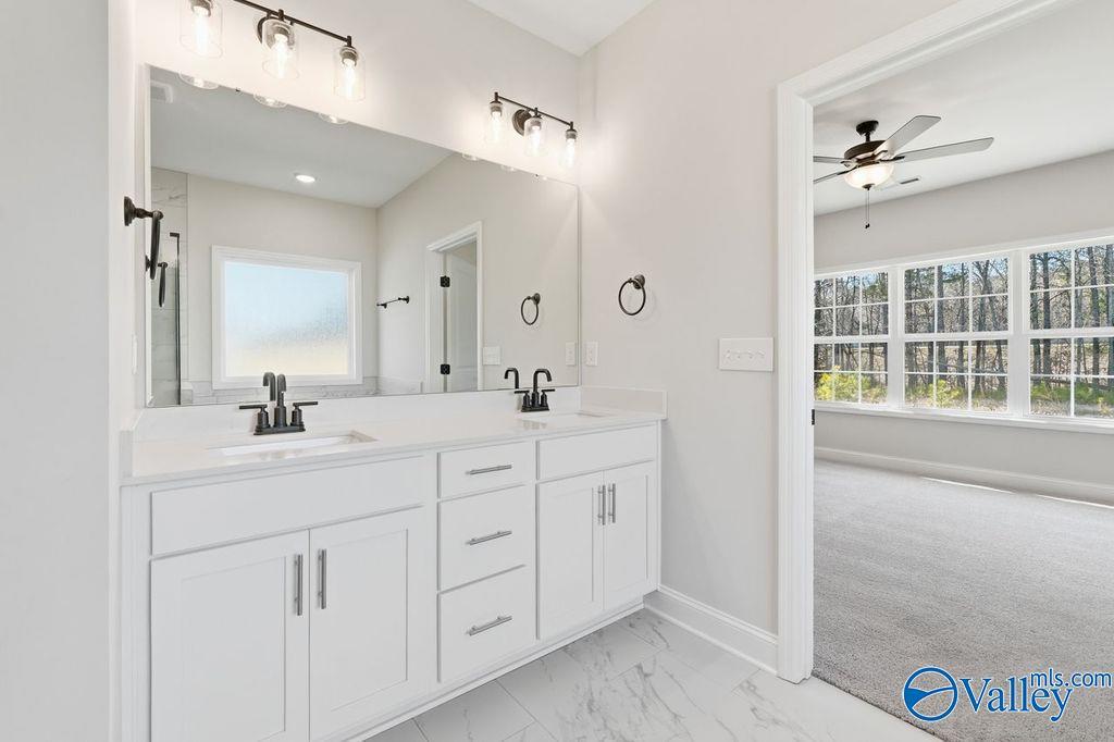 Modern master bathroom featuring double white vanity, dual sinks, mirrors, and glass shower in Davidson Homes Montgomery B, Hartselle, AL