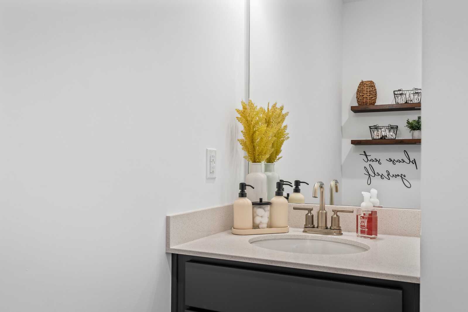 Modern bathroom vanity at The Towns at Red River in Gallatin TN featuring white quartz countertop, bronze faucet, soap dispensers, and yellow wheat decor