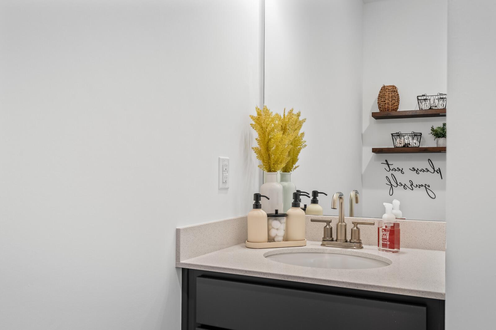 Modern bathroom vanity at The Towns at Red River in Gallatin TN featuring white quartz countertop, bronze faucet, soap dispensers, and yellow wheat decor