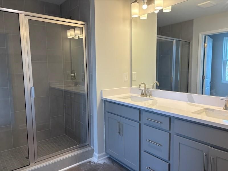 Modern master bathroom with frameless glass shower, double vanity, quartz counters in Davidson Homes The Marion A, Winder GA