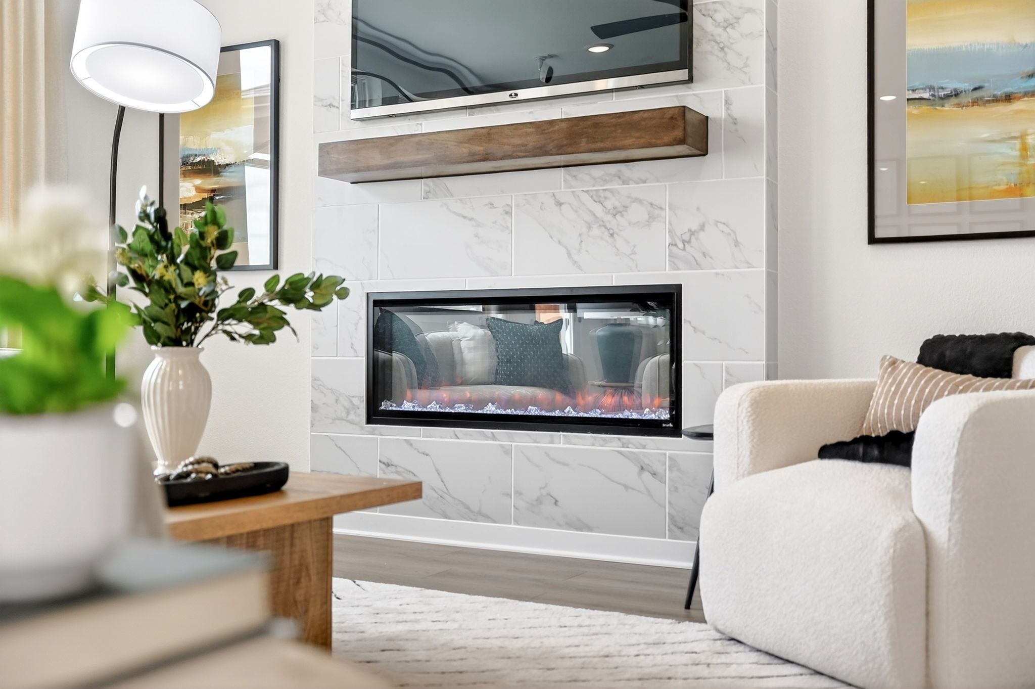 Modern fireplace with marble tile surround and wood mantel at Parks at Foster Crossing in Anna, TX by Davidson Homes