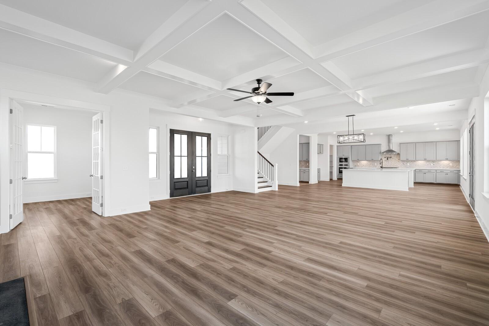 Grand entry foyer with coffered ceiling, hardwood floors, staircase, and open kitchen in Davidson Homes The Alston A, Murfreesboro