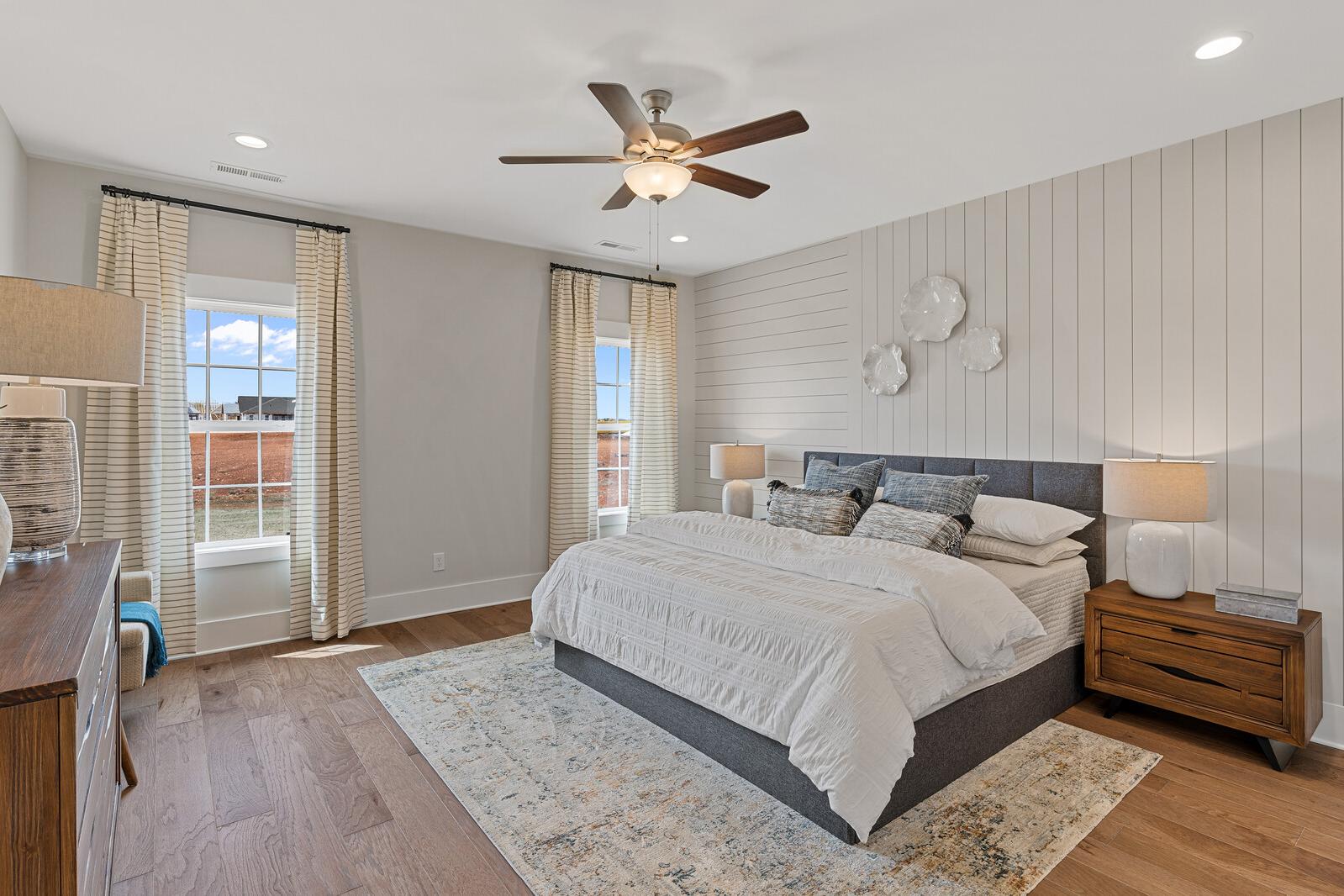 A decorated master bedroom with a shiplap accent wall