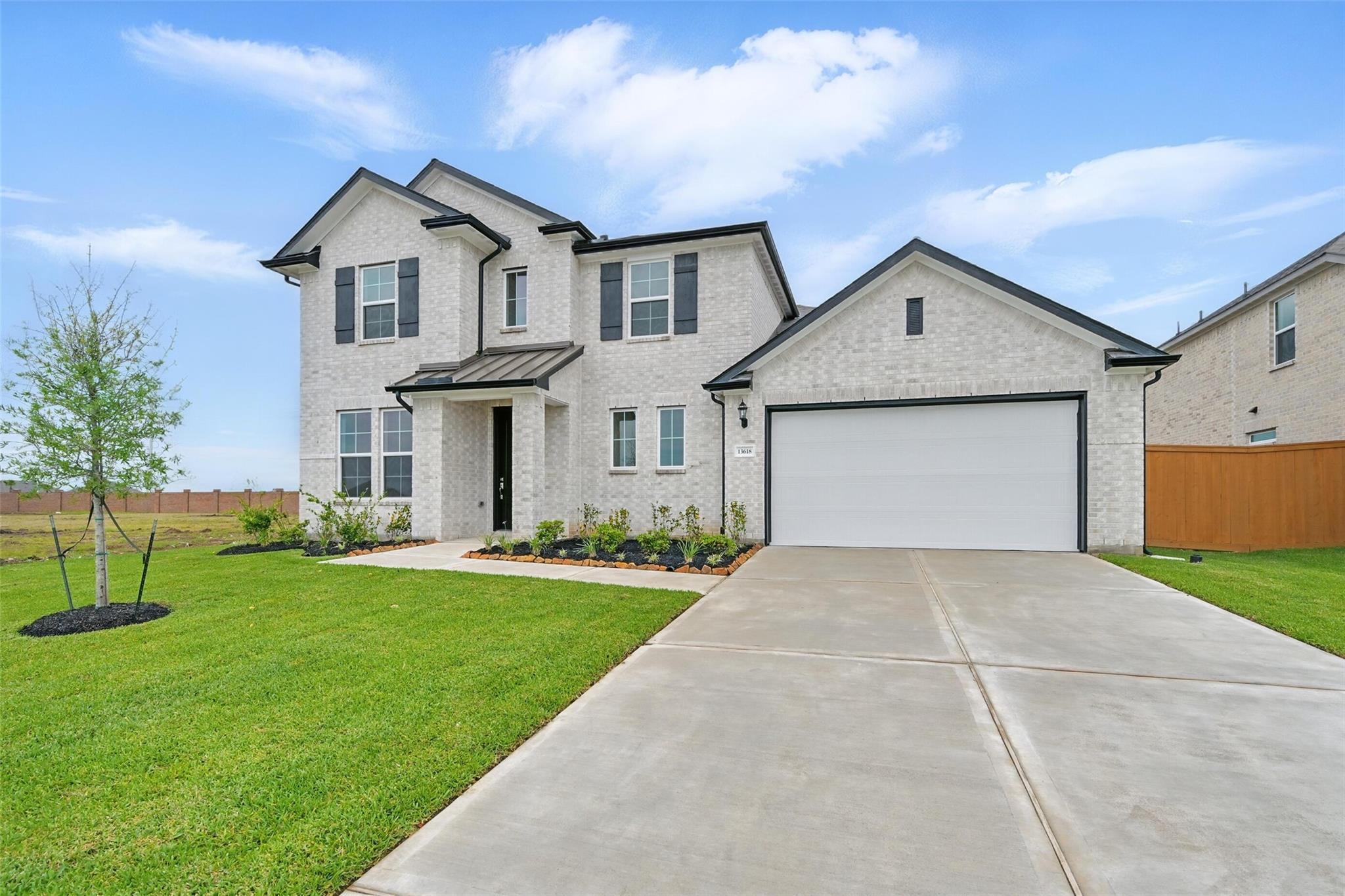 Modern two-story white brick home with 3-car garage, front porch, and landscaped yard in Lago Mar, Texas City - Davidson Homes The Philip A