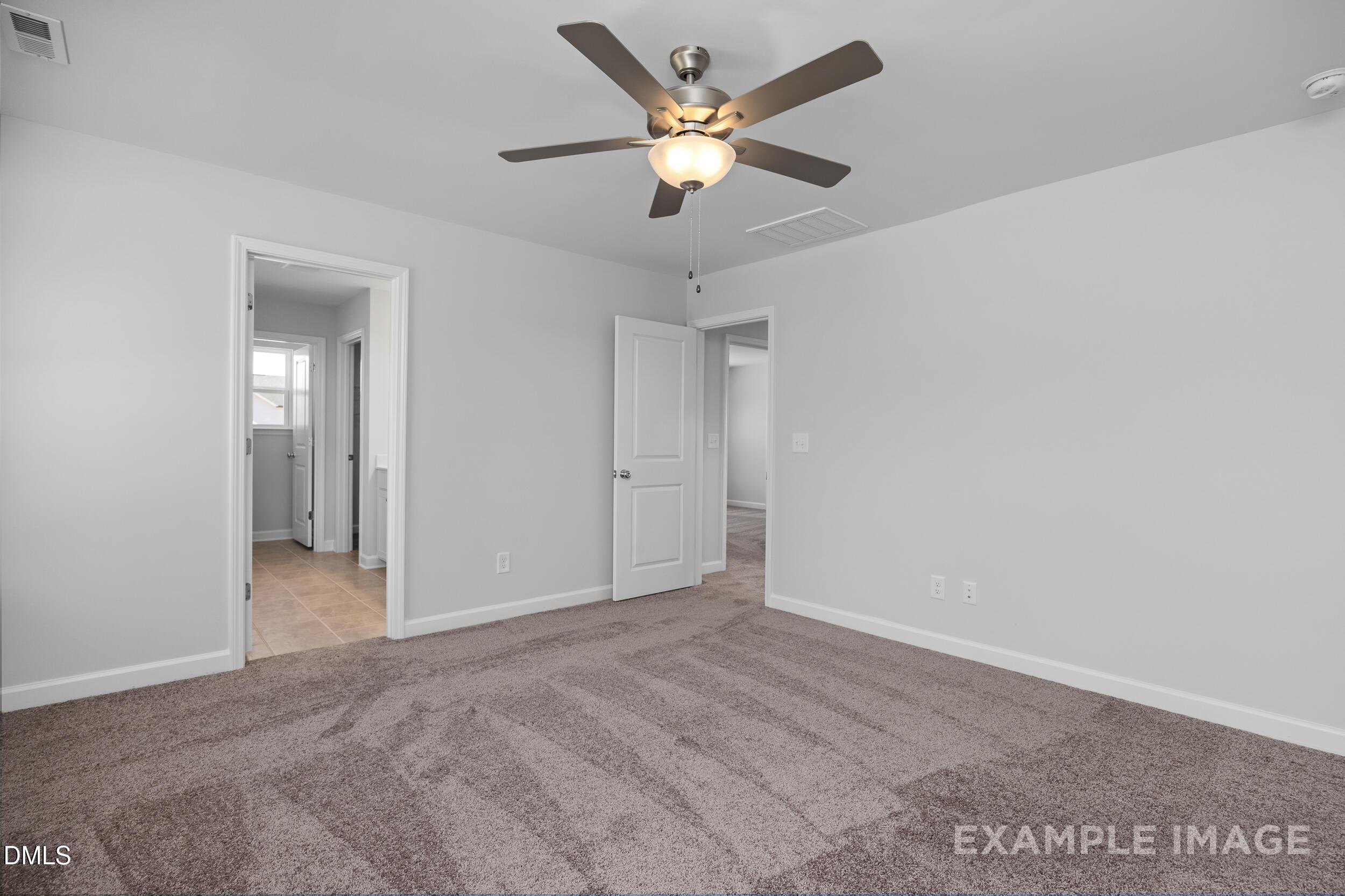 Spacious carpeted bedroom with ceiling fan in The Gavin A floor plan by Davidson Homes in Gregory Village, Lillington, NC.