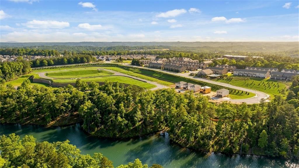 Aerial view of The Bluffs community in Canton, Georgia, with Davidson Homes townhomes, lush trees, green spaces, and scenic riverfront