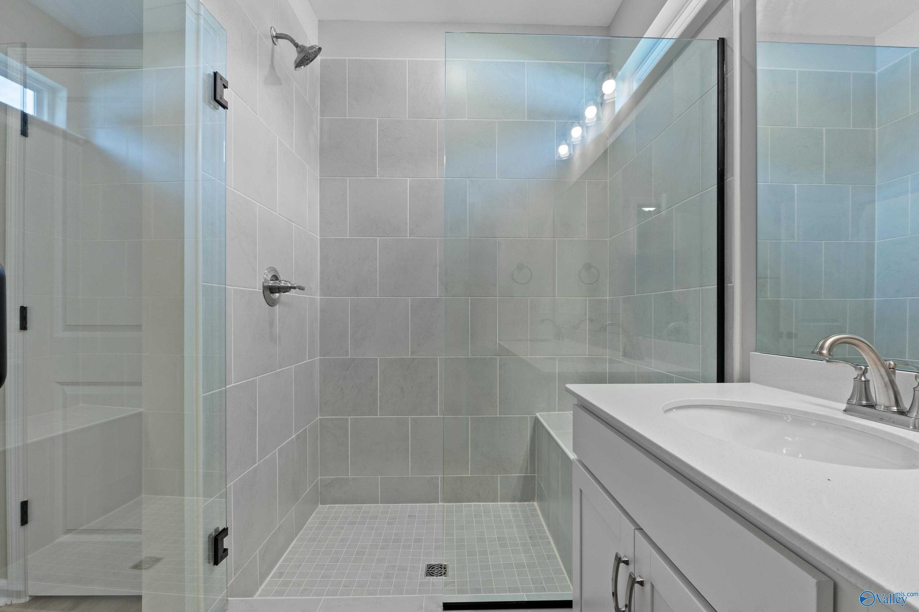 Modern walk-in shower with frameless glass doors and subway tile in Davidson Homes The Phoenix bathroom, Fayetteville, TN