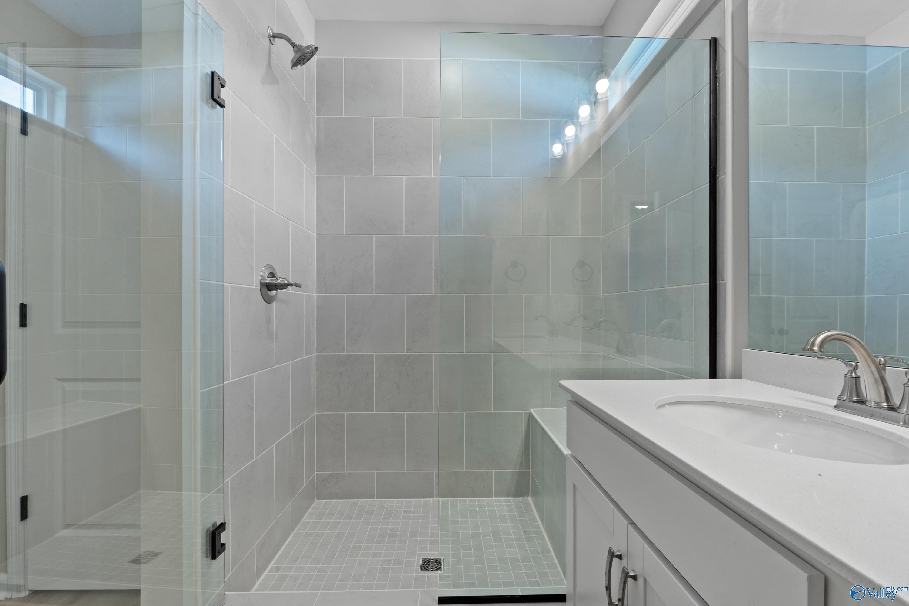 Modern walk-in shower with frameless glass doors, subway tile, and vanity in Davidson Homes The Phoenix, Fayetteville, Tennessee