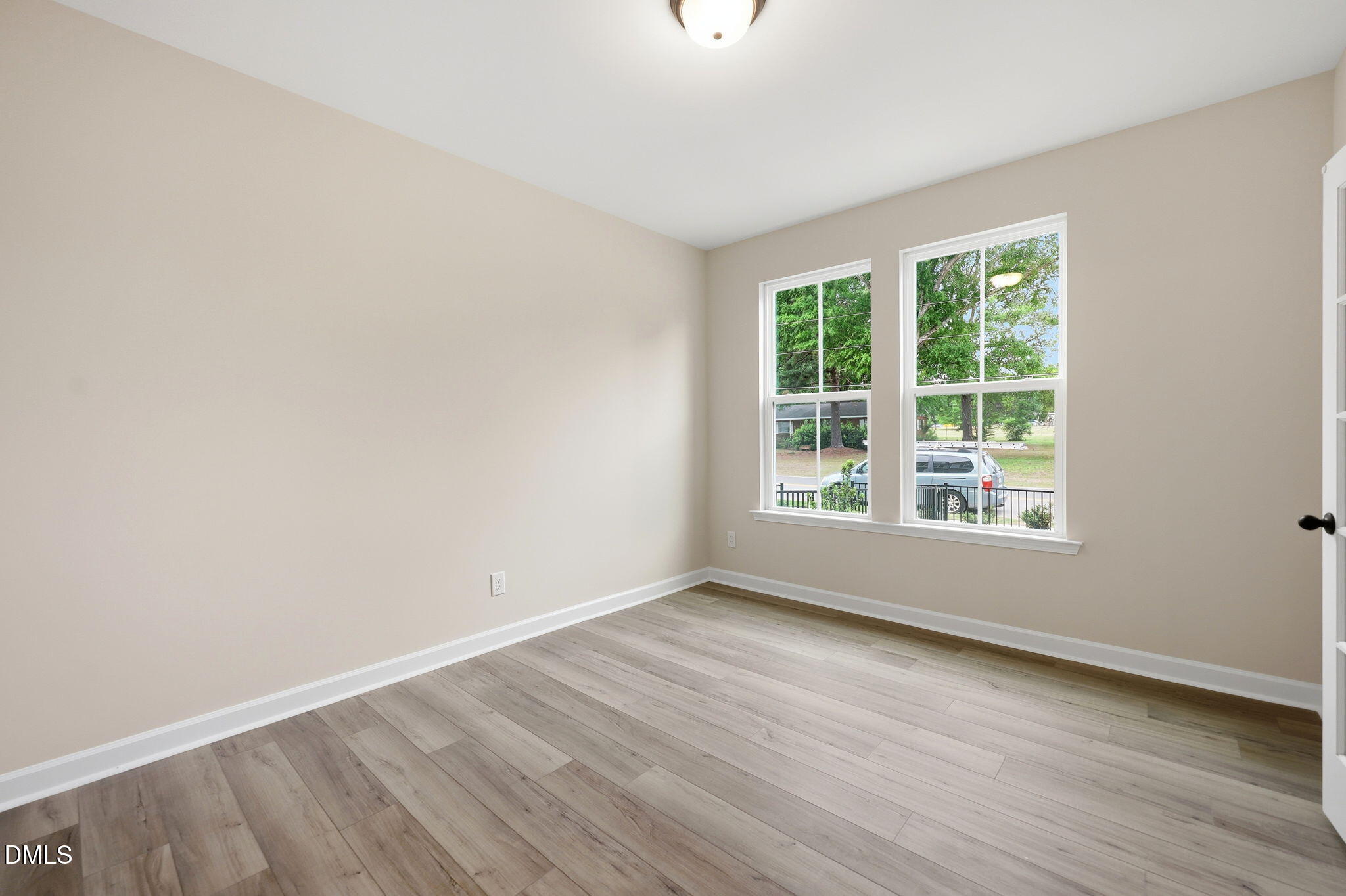 Bright bedroom with wood-look flooring in The Mitchell floor plan at Camden Park, Knightdale, North Carolina.