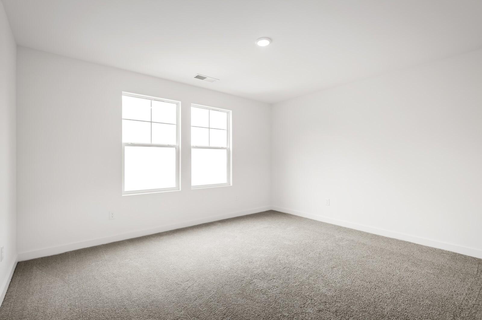Bright, spacious secondary bedroom with plush carpet in The Logan C floor plan at Calista Farms in White House, Tennessee.