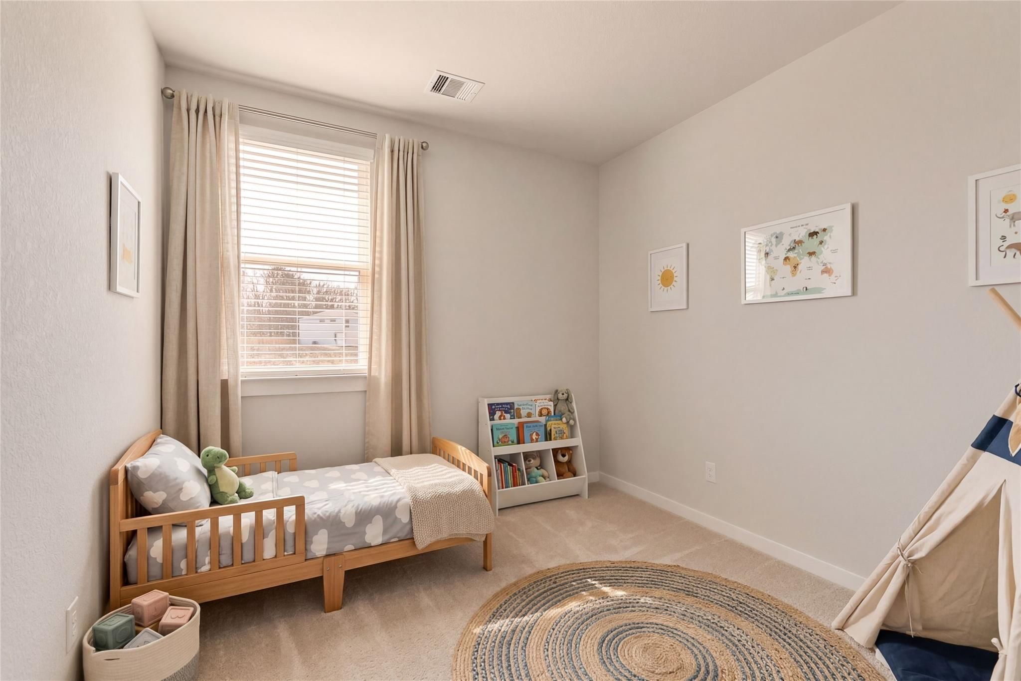 Charming toddler bedroom with wooden crib bed, bookshelf, teepee tent, and round rug in Davidson Homes Colorado F, Cleveland, Texas